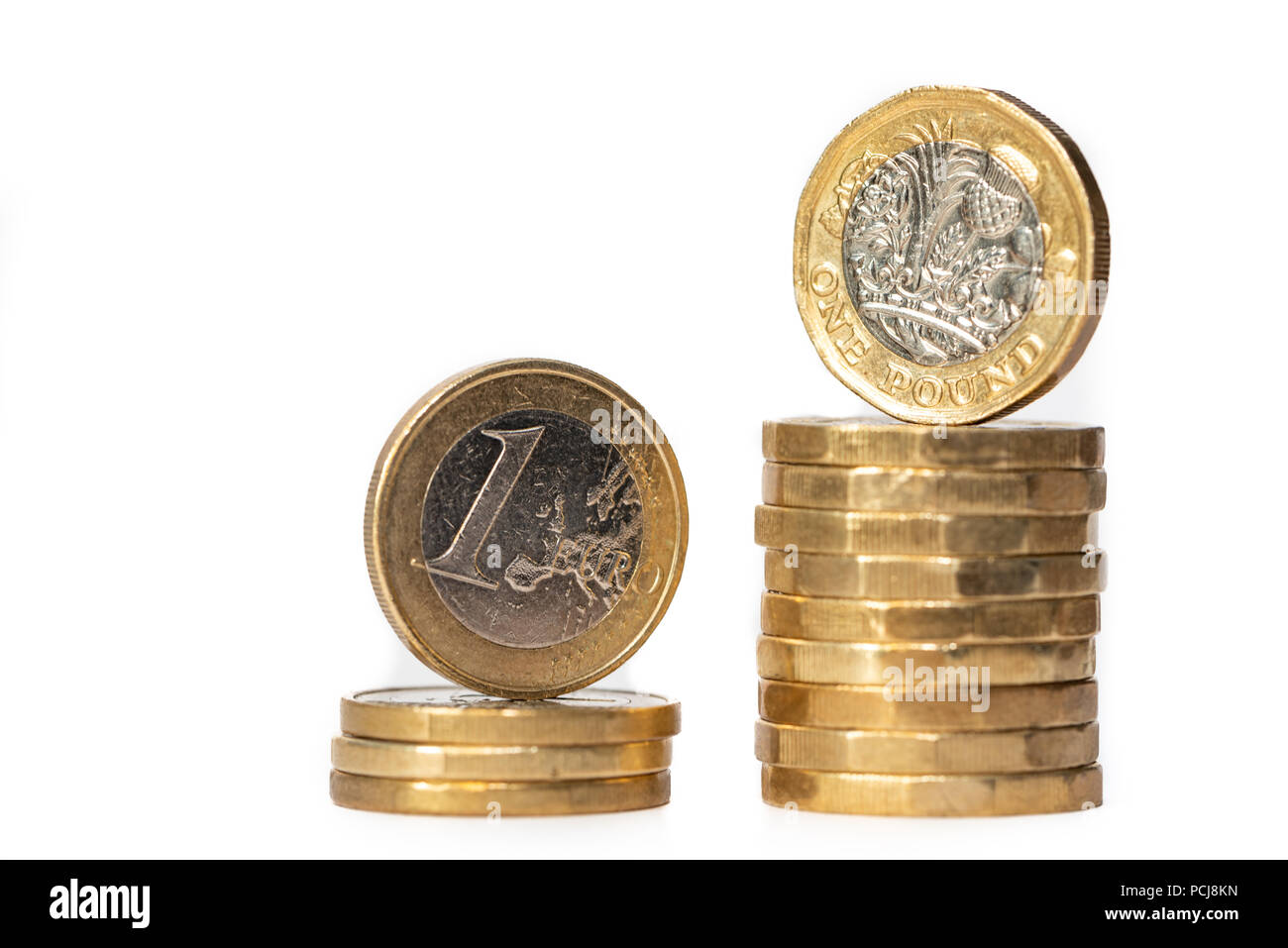 Pila di monete metalliche in euro e sterlina nuove monete isolati su sfondo bianco Foto Stock