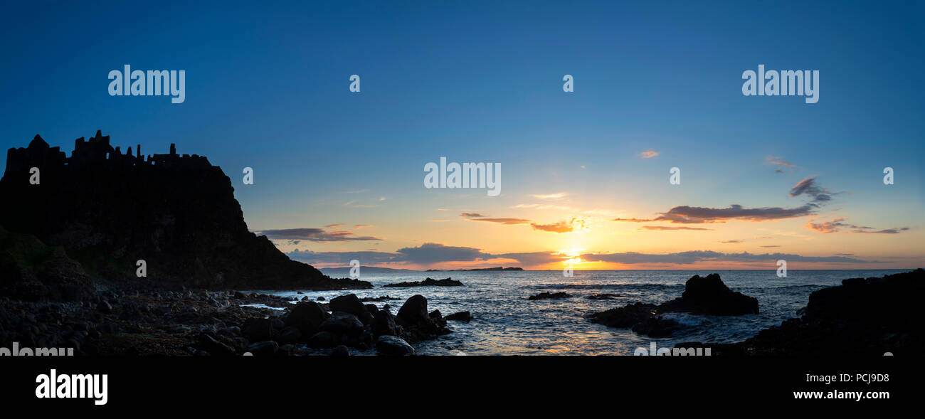 Rovine del Castello di Dunluce stagliano dal sunsetting sulla costa irlandese Foto Stock