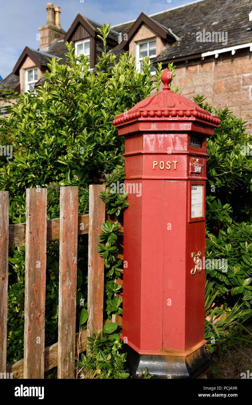 Red Royal Mail casella postale con evergreen Hebe bush a Baile Mor villaggio sull isola di Iona Ebridi Interne in Scozia UK Foto Stock