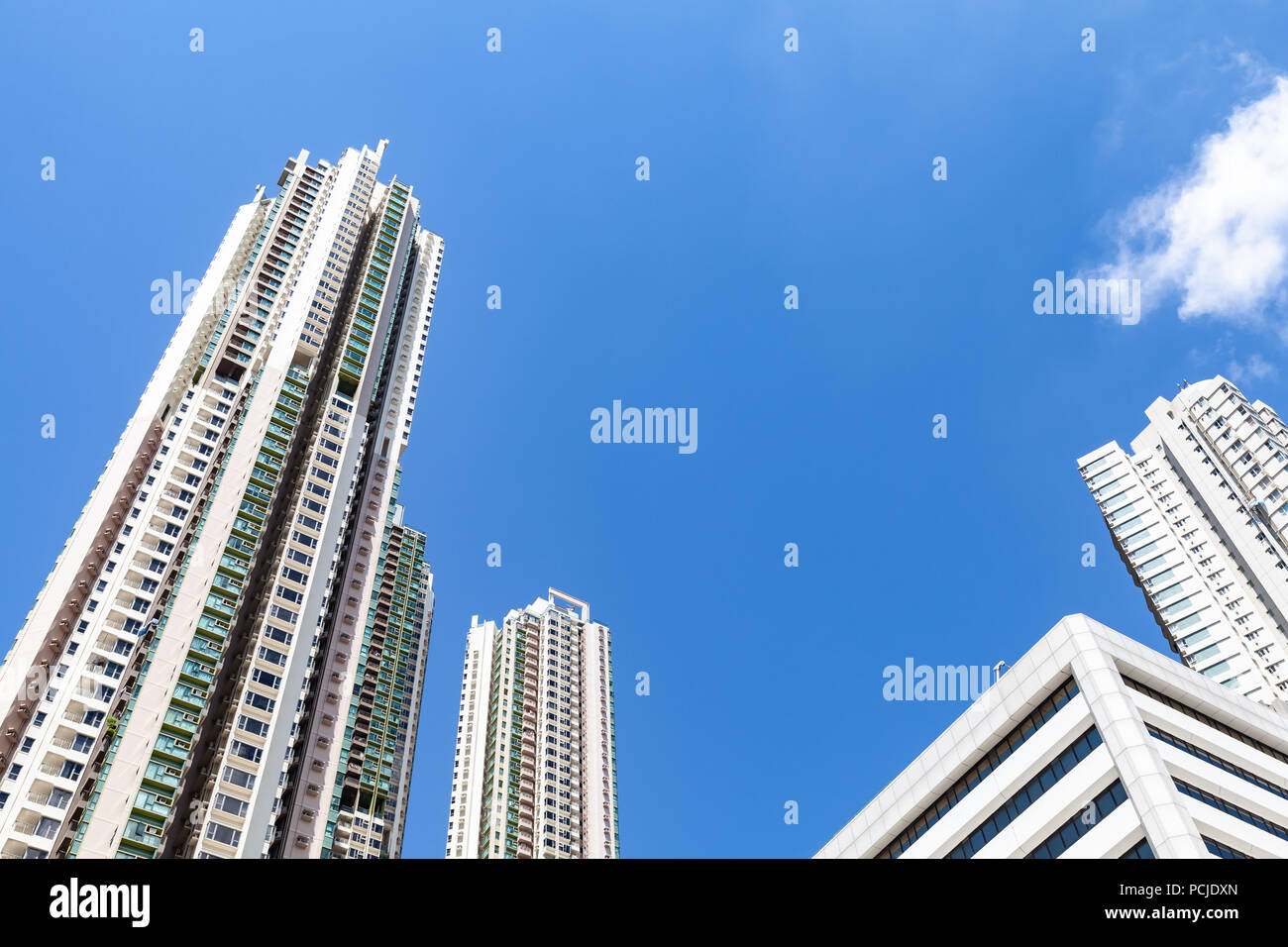 Urban Skyline con grattacieli sotto il cielo blu. Alto edificio di torri in calcestruzzo. Case di vita di Hong Kong Foto Stock