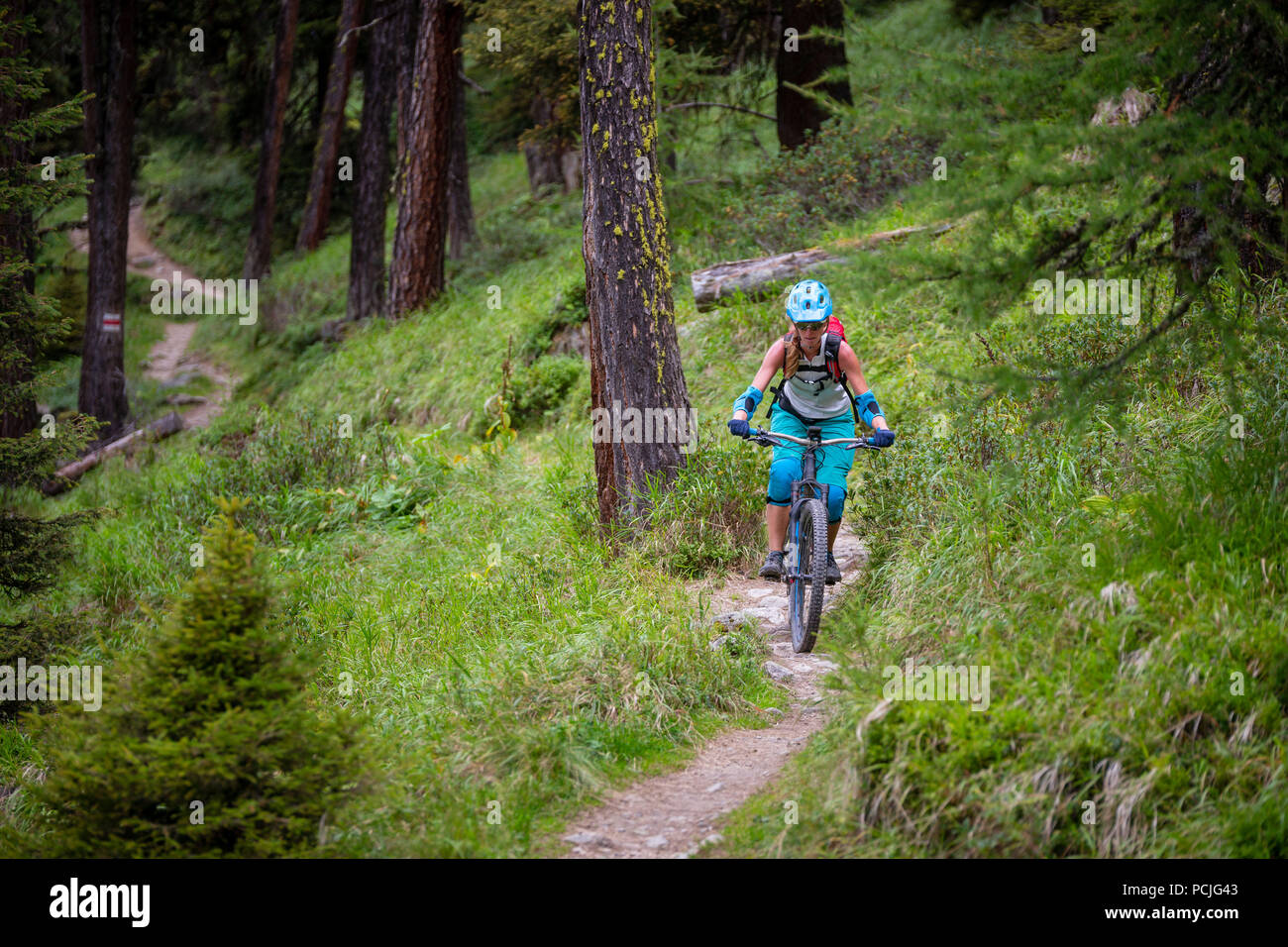 Woman mountain bike nelle alpi svizzere vicino a Davos, Grigioni, Svizzera Foto Stock