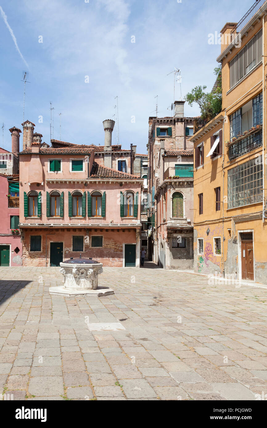 Campo della Maddalena, Cannaregio, Venezia, Veneto, Italia con le sue pittoresche case medievali e i camini di veneziano intorno ad un antico pozzo di testa o di poz Foto Stock