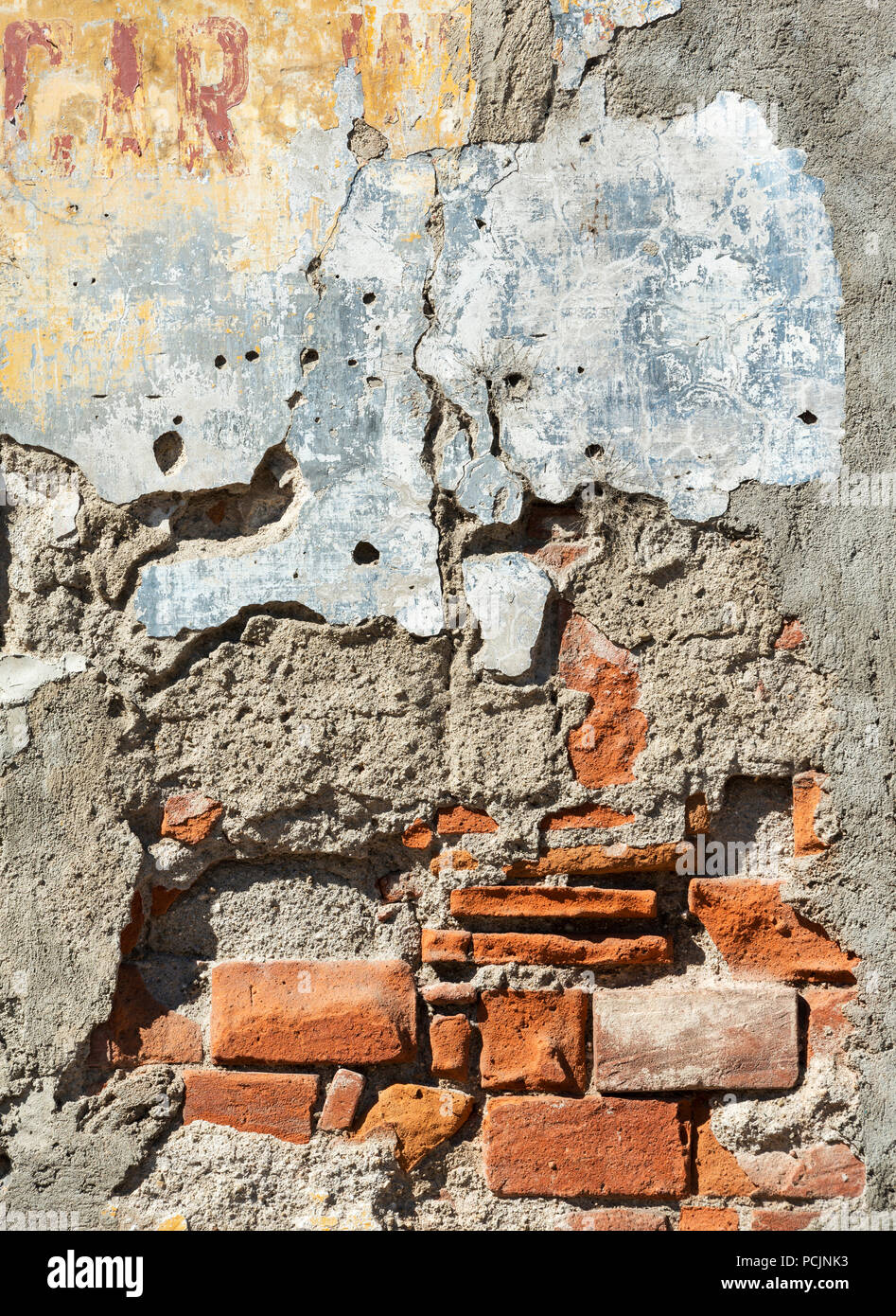 Vecchio danneggiato un muro di mattoni con intonaco falling off Foto stock  - Alamy
