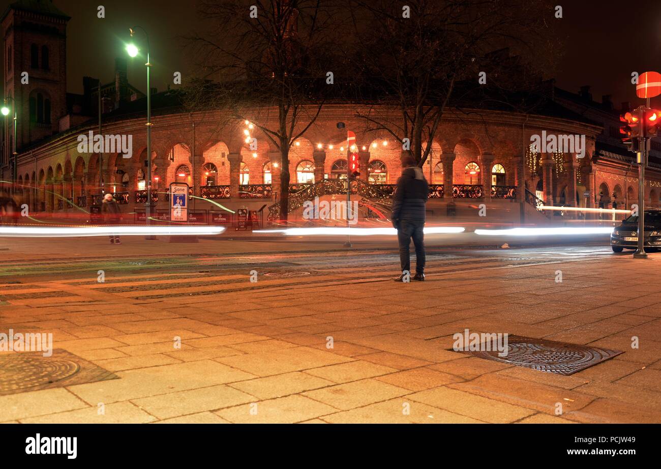 Un uomo in attesa del semaforo verde per andare al di là della strada in Oslo Foto Stock