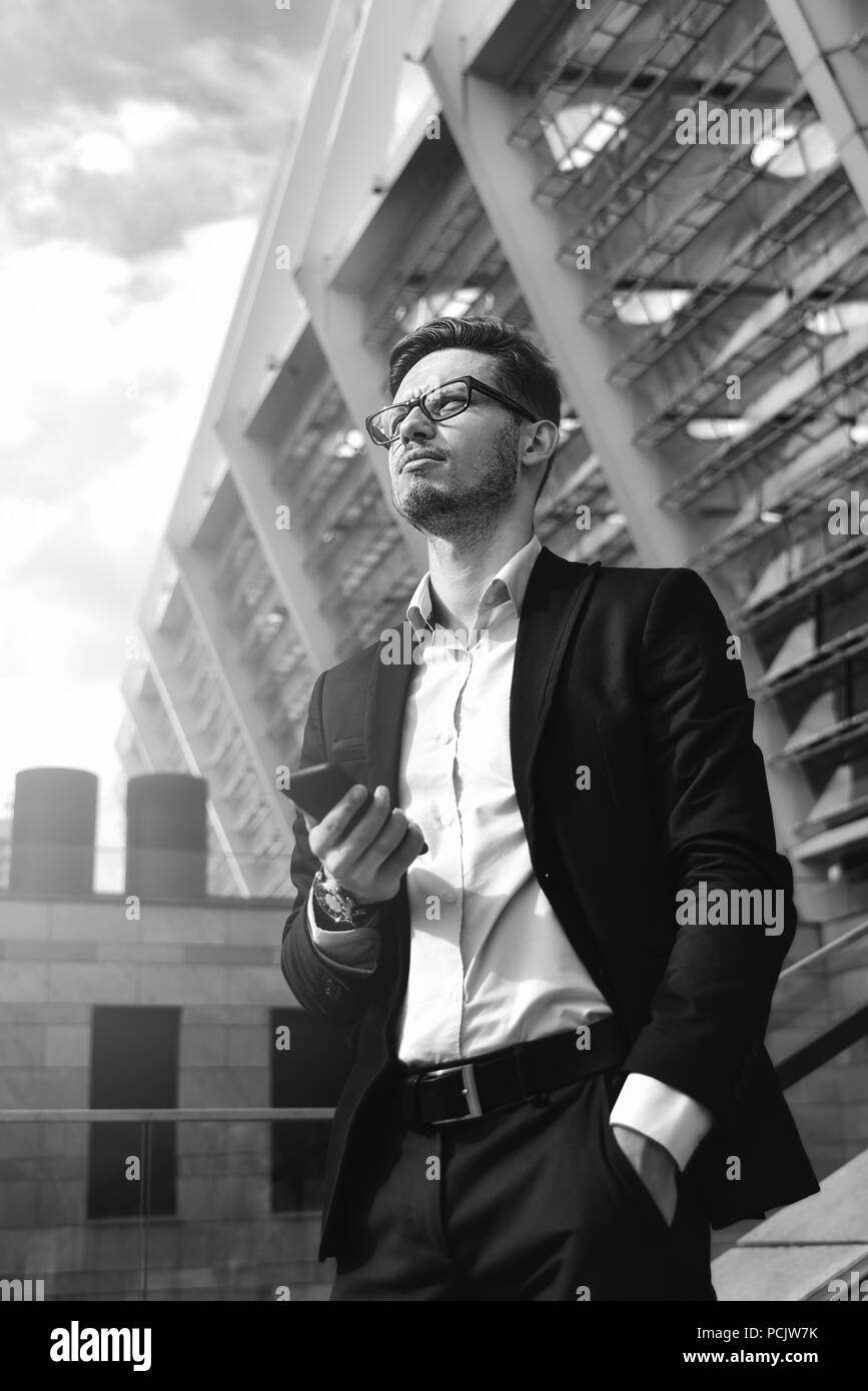 Bel imprenditore di successo in elegante abito all'aperto a camminare sulla via della città. Foto Stock