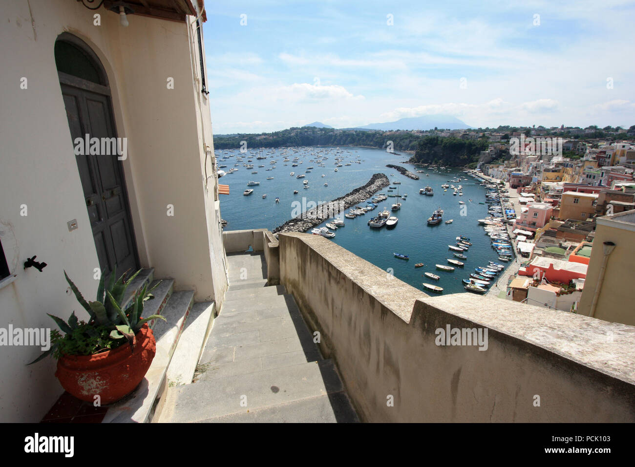 Vista panoramica del lungomare di Corricella a Procida, Golfo di Napoli, Italia, con il vivacemente colorate case dipinte in diverse sfumature pastello Foto Stock