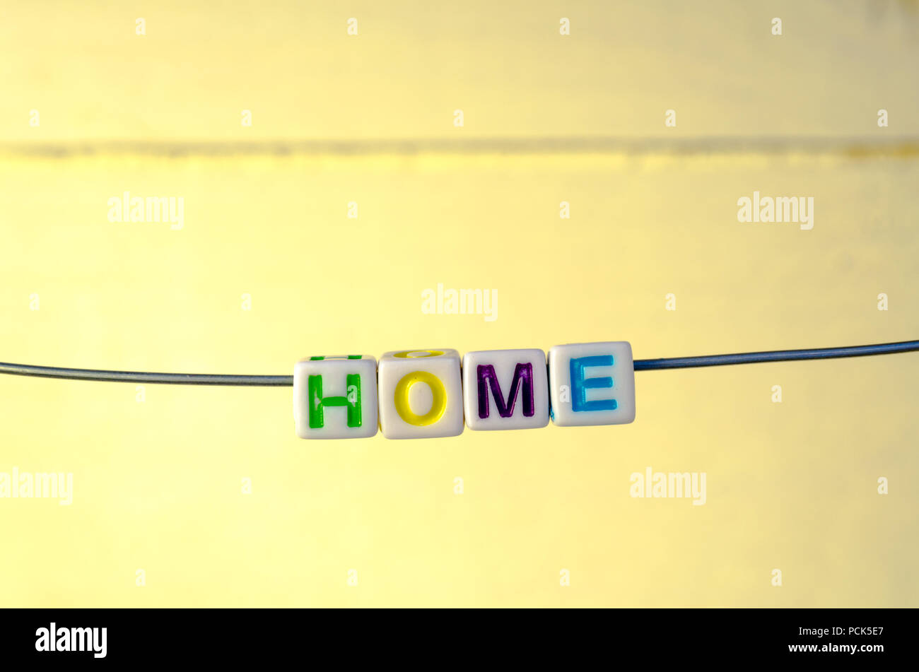 Uno studio fotografico di perline in ordine alfabetico sospeso su un filo ortografia 'Home' Foto Stock