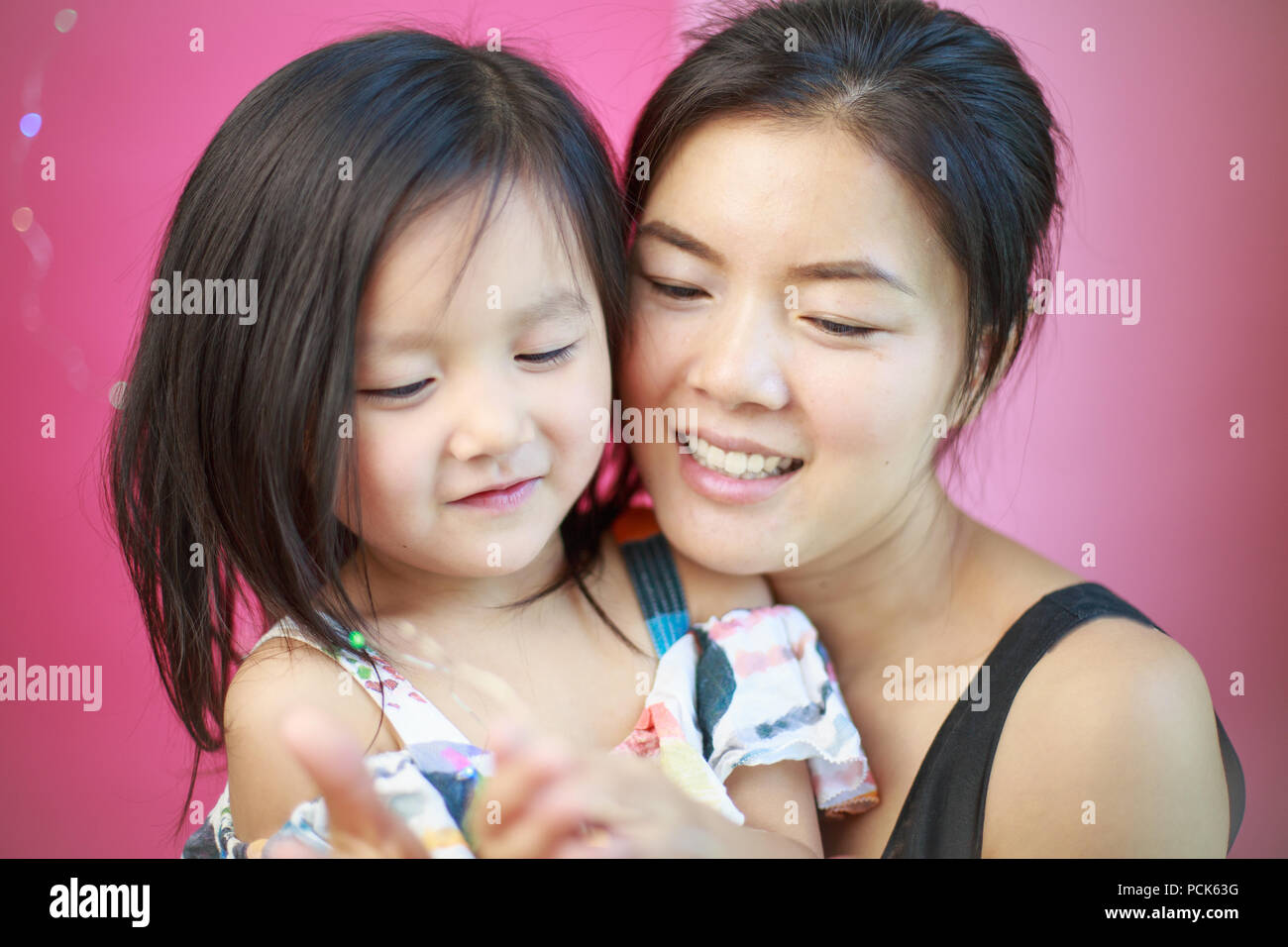 Una bellezza orientale e la sua bella figlia，un cinese sorridente madre e figlia Foto Stock