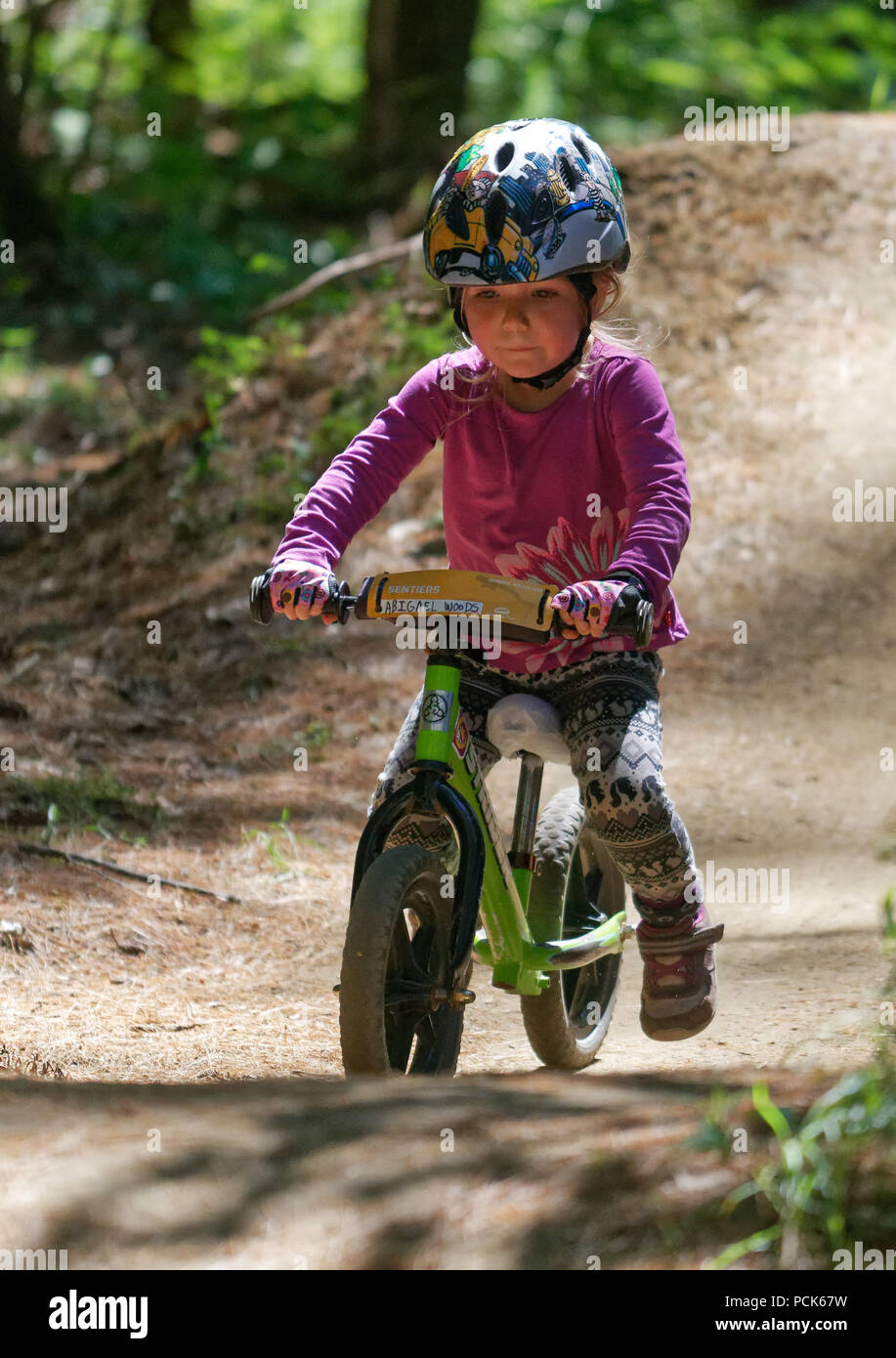 Una bambina (3 anni) in sella il suo equilibrio bike nel Regno sentieri atEast Burke, Vermont, USA Foto Stock