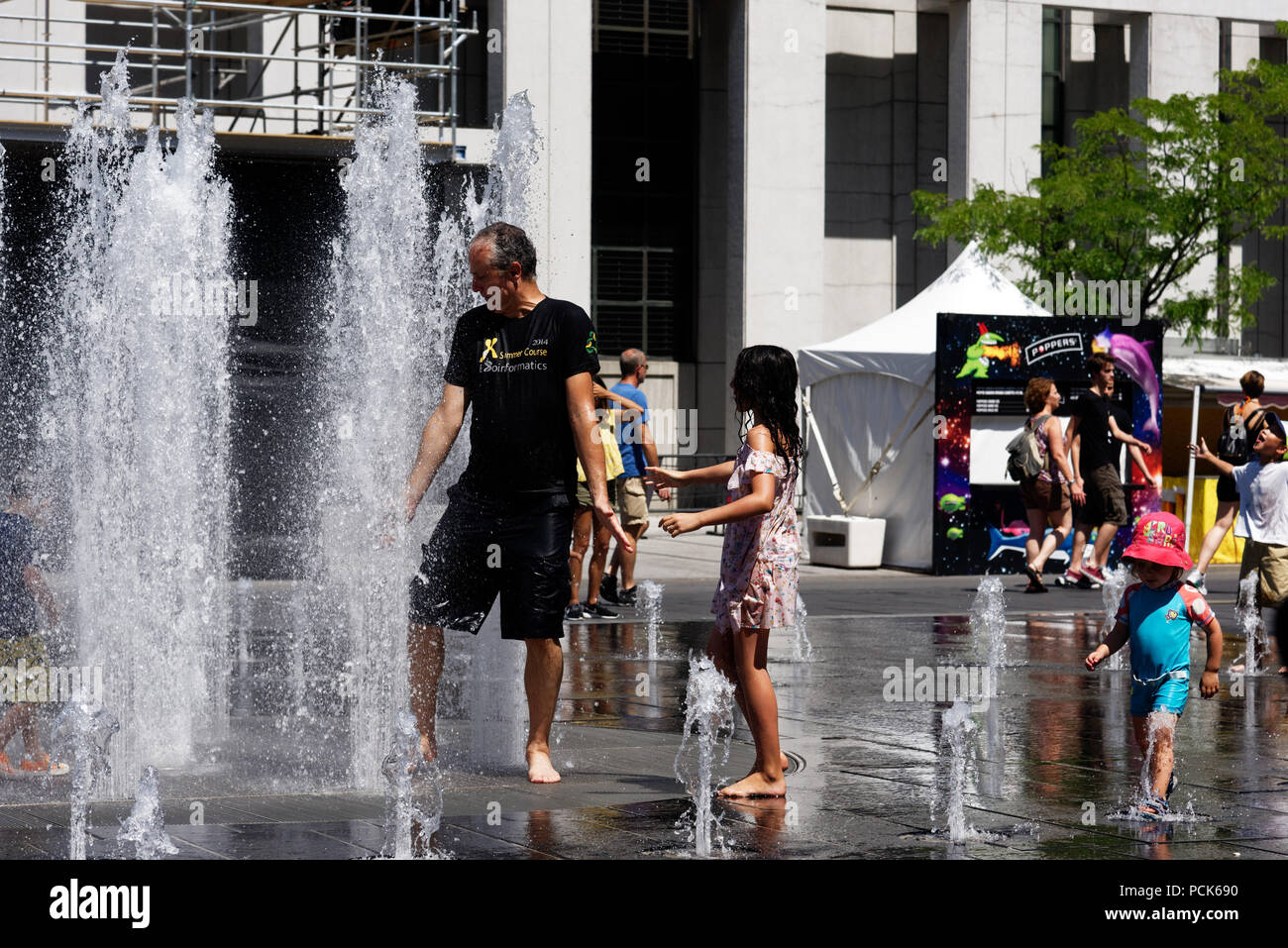 Persone mantenendo raffreddare in acqua delle fontane a Montreal nel 2018 canicola Foto Stock