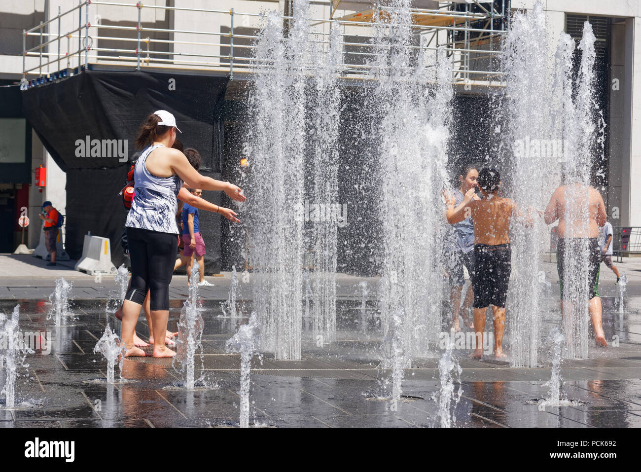 Persone mantenendo raffreddare in acqua delle fontane a Montreal nel 2018 canicola Foto Stock