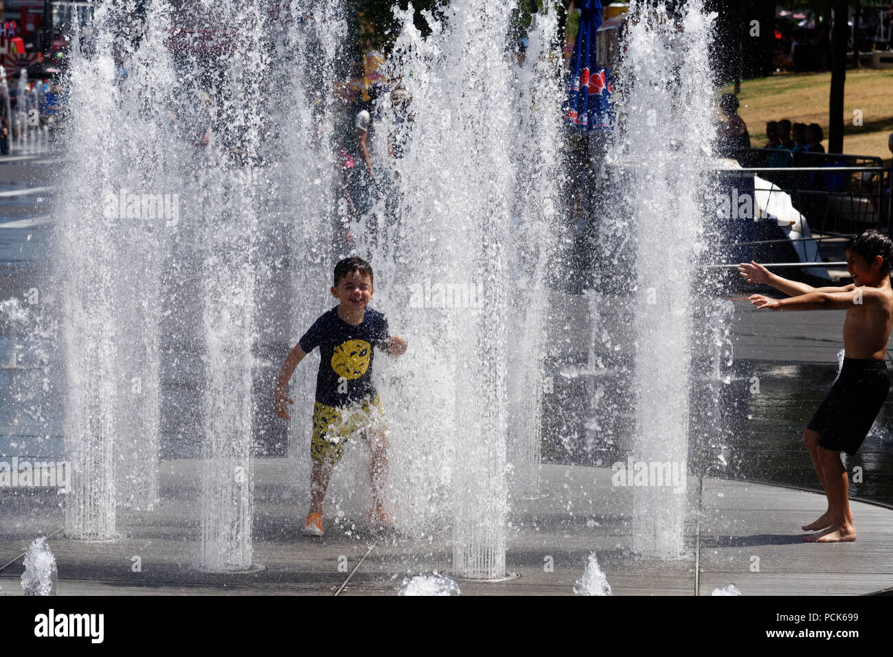 Bambini raffreddamento fuori a giocare in acqua fontane in su Rue Jeanne previsti Montreals nel quartiere dei divertimenti. Prese durante il 2108 ondata di caldo. Foto Stock