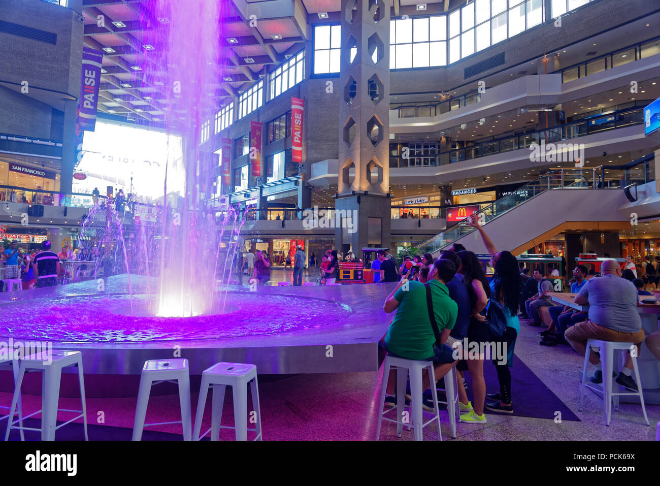 Un gruppo di giovani di scattare le foto di una grande fontana in Complexe Desjardins centro dello shopping nel centro cittadino di Montreal Foto Stock