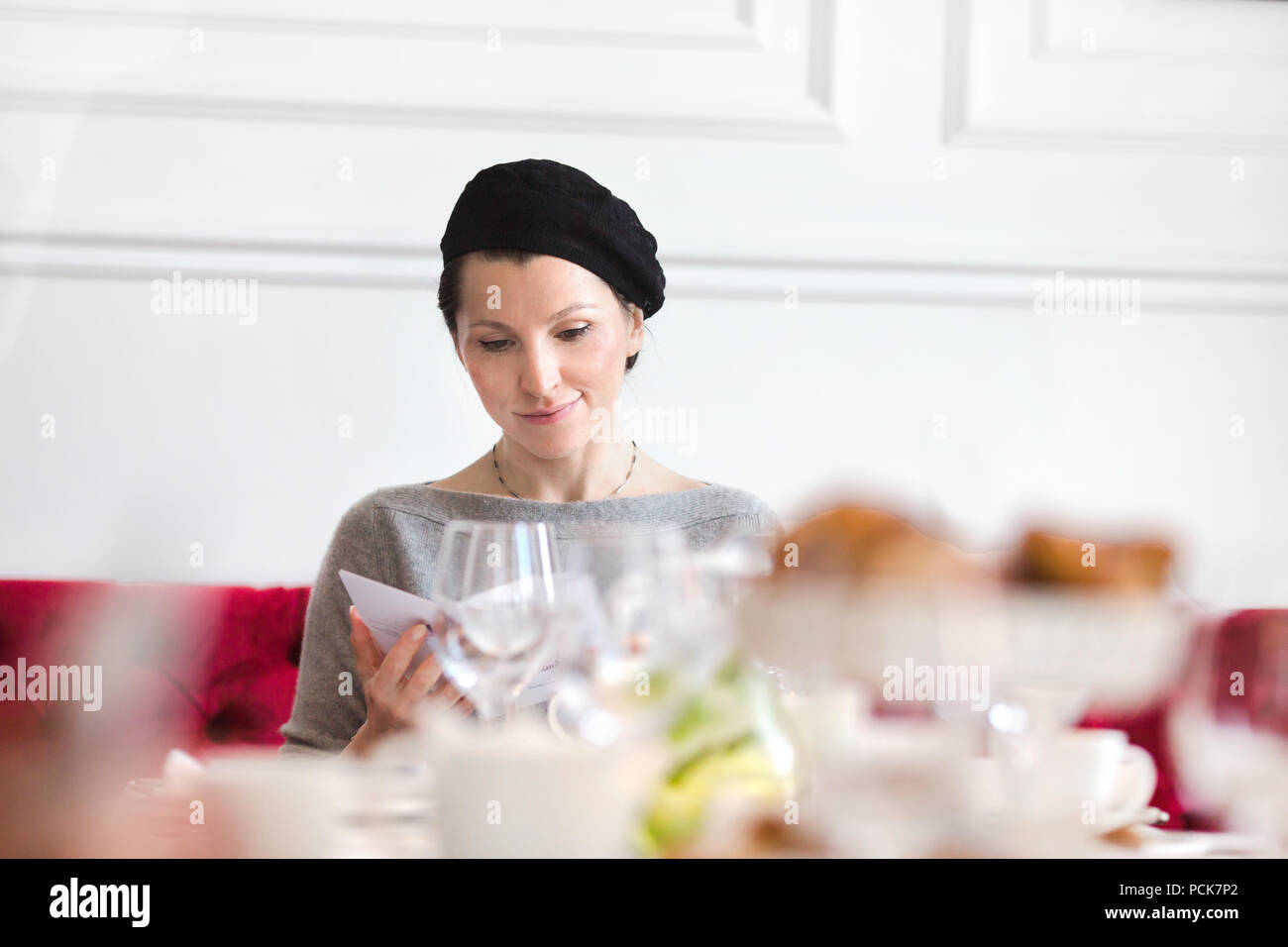 Donna elegante al tavolo nella sala banchetti Foto Stock