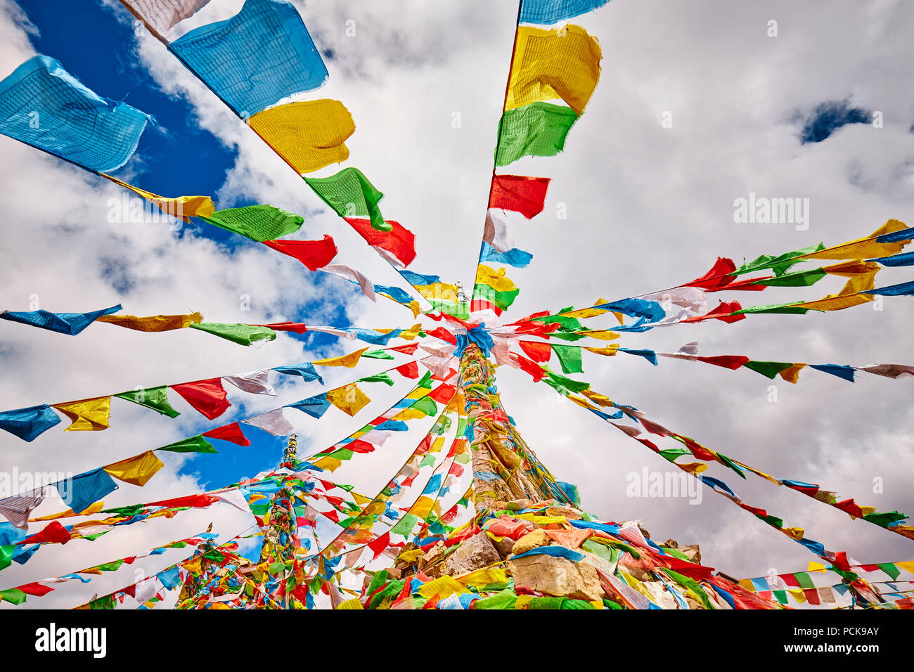 Guardando verso l'alto la preghiera buddista bandiere. Tibetani ritengono le preghiere e mantra verrà soffiata dal vento per diffondere la buona volontà e la compassione. Foto Stock