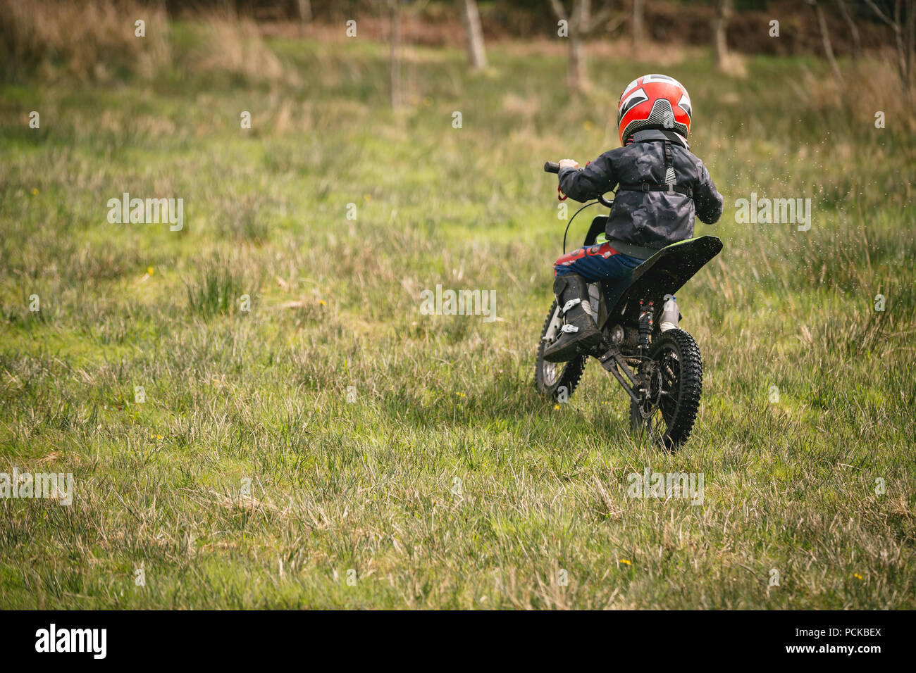 Kid in sella a una moto in giardino Foto Stock