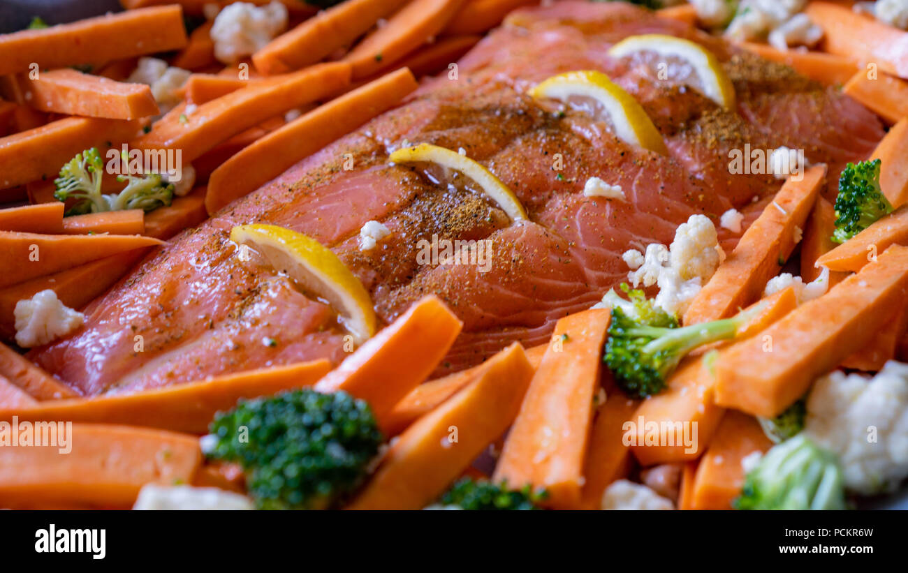 Pesce rosso salmone con patate dolci, broccoli e cavolfiori per la cottura in forno. cibo sano Foto Stock