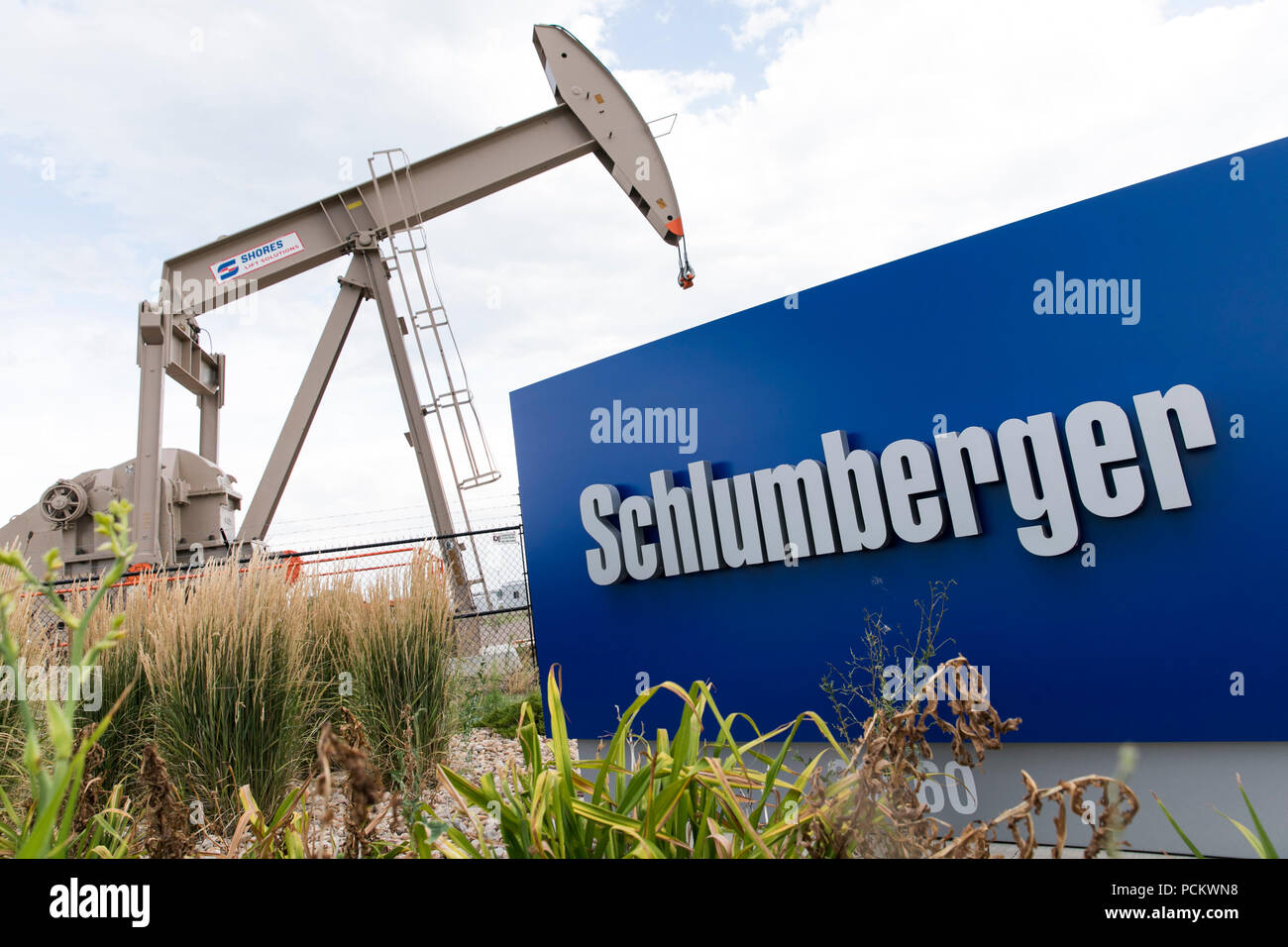 Un segno del logo e della pompa olio al di fuori di una struttura occupata da Schlumberger in Windsor, Colorado, il 21 luglio 2018. Foto Stock