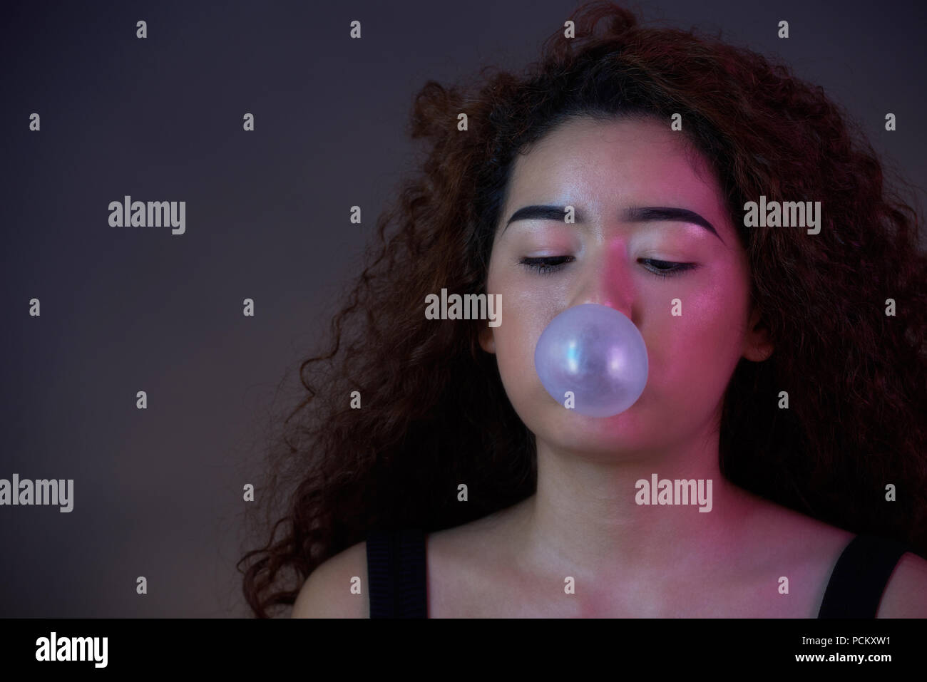 Ragazza adolescente blow bubble gum ball close-up verticale Foto Stock