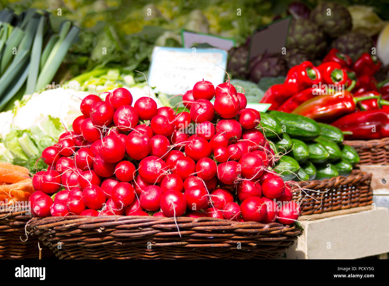 Rosso fresco ravanelli in un cesto su un mercato contadino store per la presentazione con altri sani alimenti biologici Foto Stock