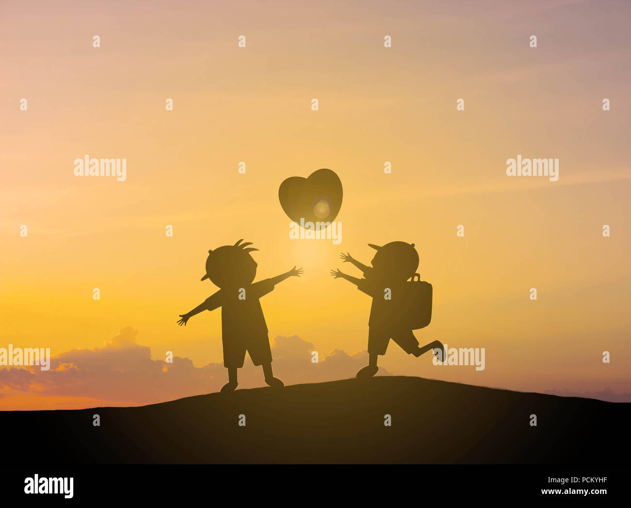 Silhouette bambini giocano a forma di cuore di palloncini con tramonto Foto Stock