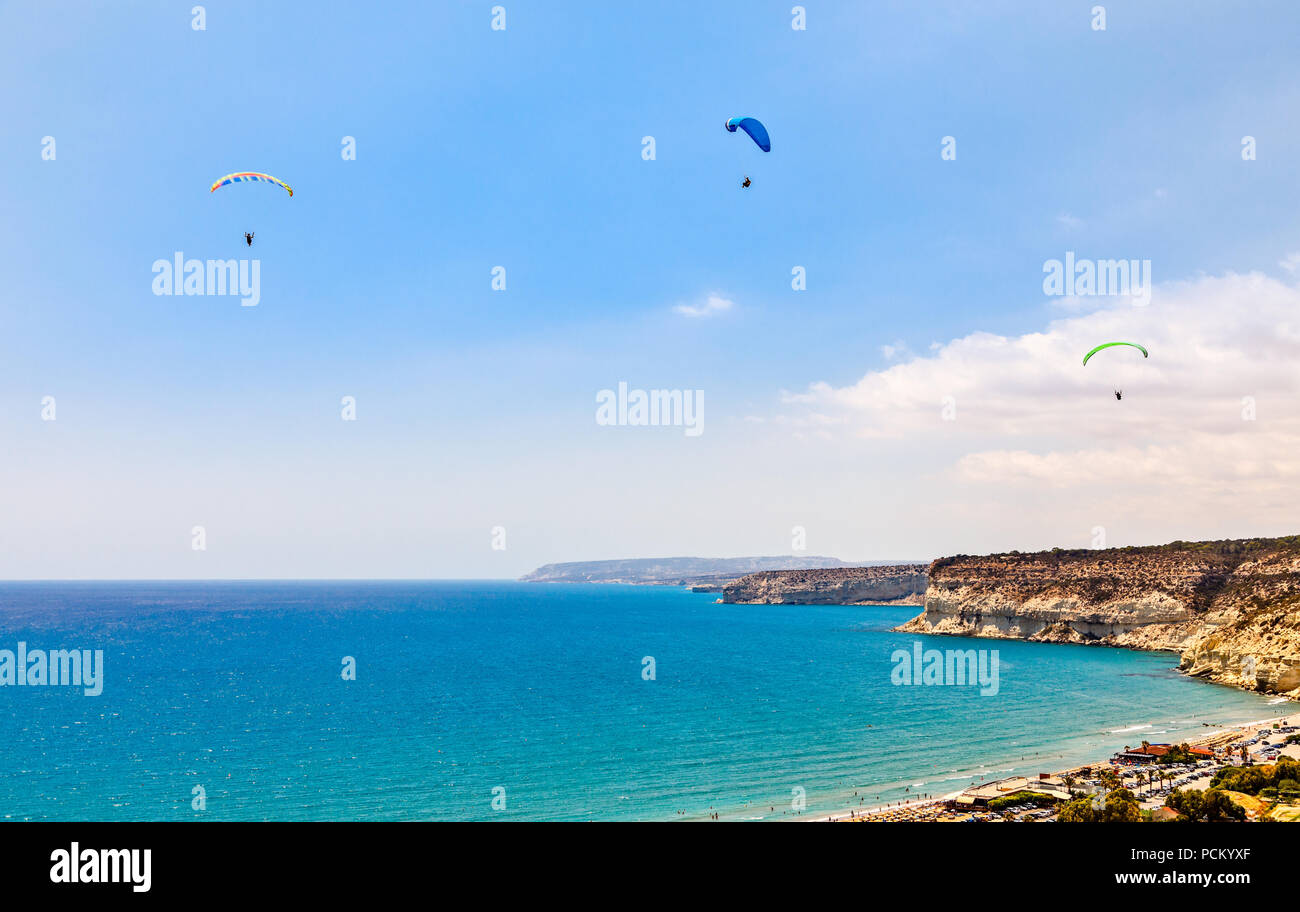 Tre i parapendii volare sopra le Kurion spiaggia e mare mediterraneo paesaggio, Limassol, Cipro Foto Stock