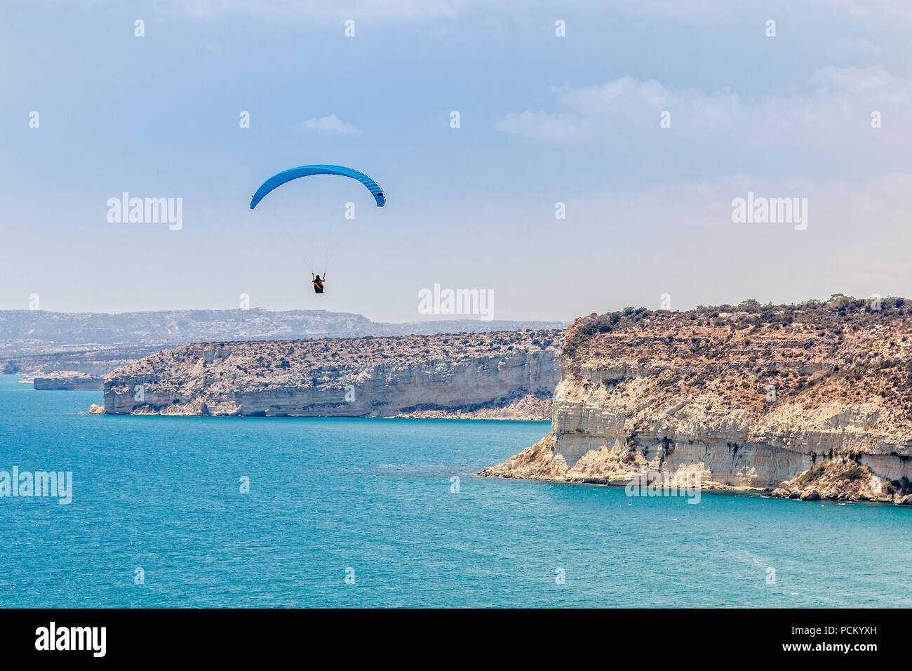 Parapendio volare sopra le scogliere di Kurion e mare mediterraneo paesaggio, Limassol, Cipro Foto Stock