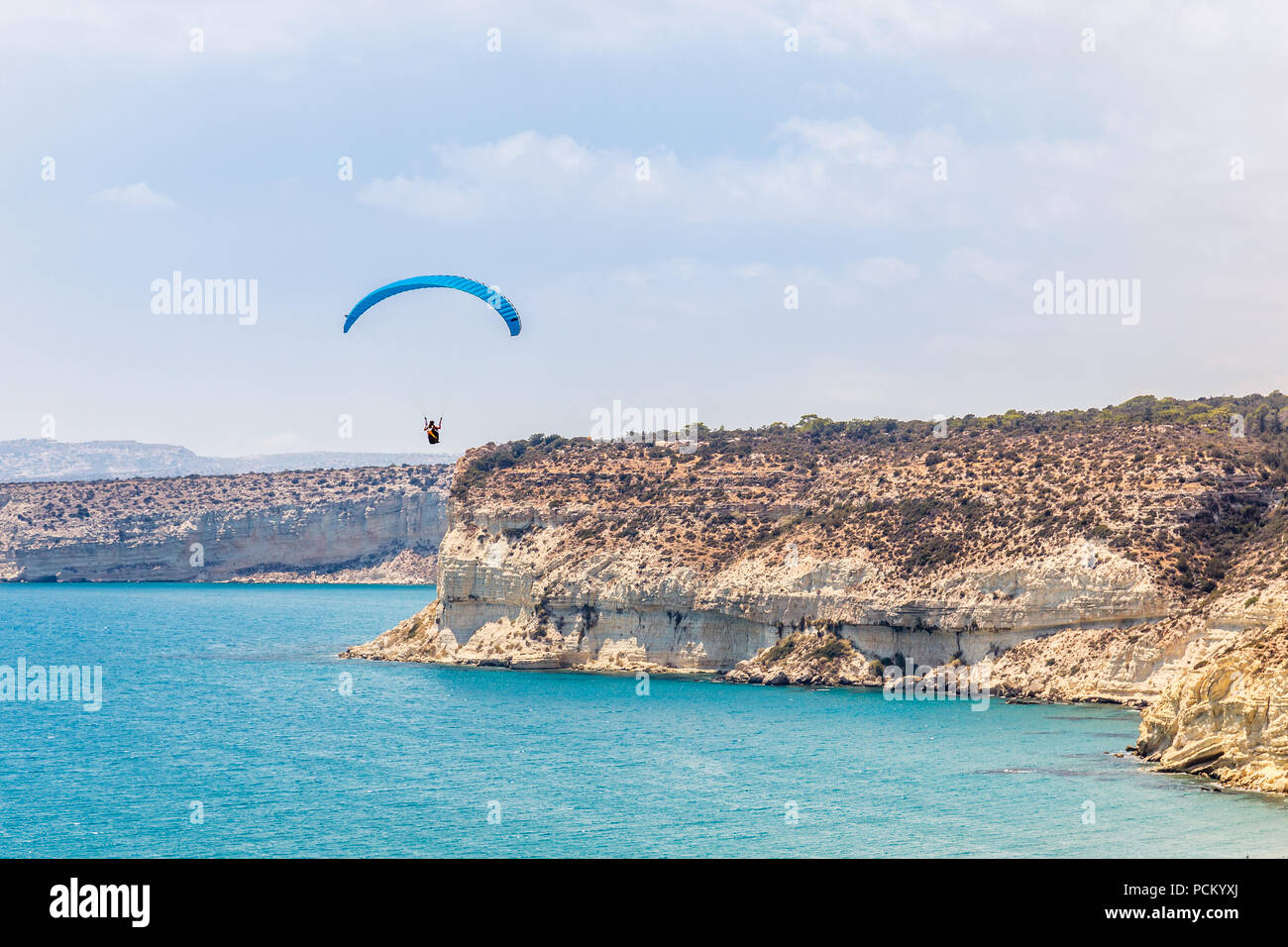 Parapendio volare sopra le scogliere di Kurion e mare mediterraneo paesaggio, Limassol, Cipro Foto Stock