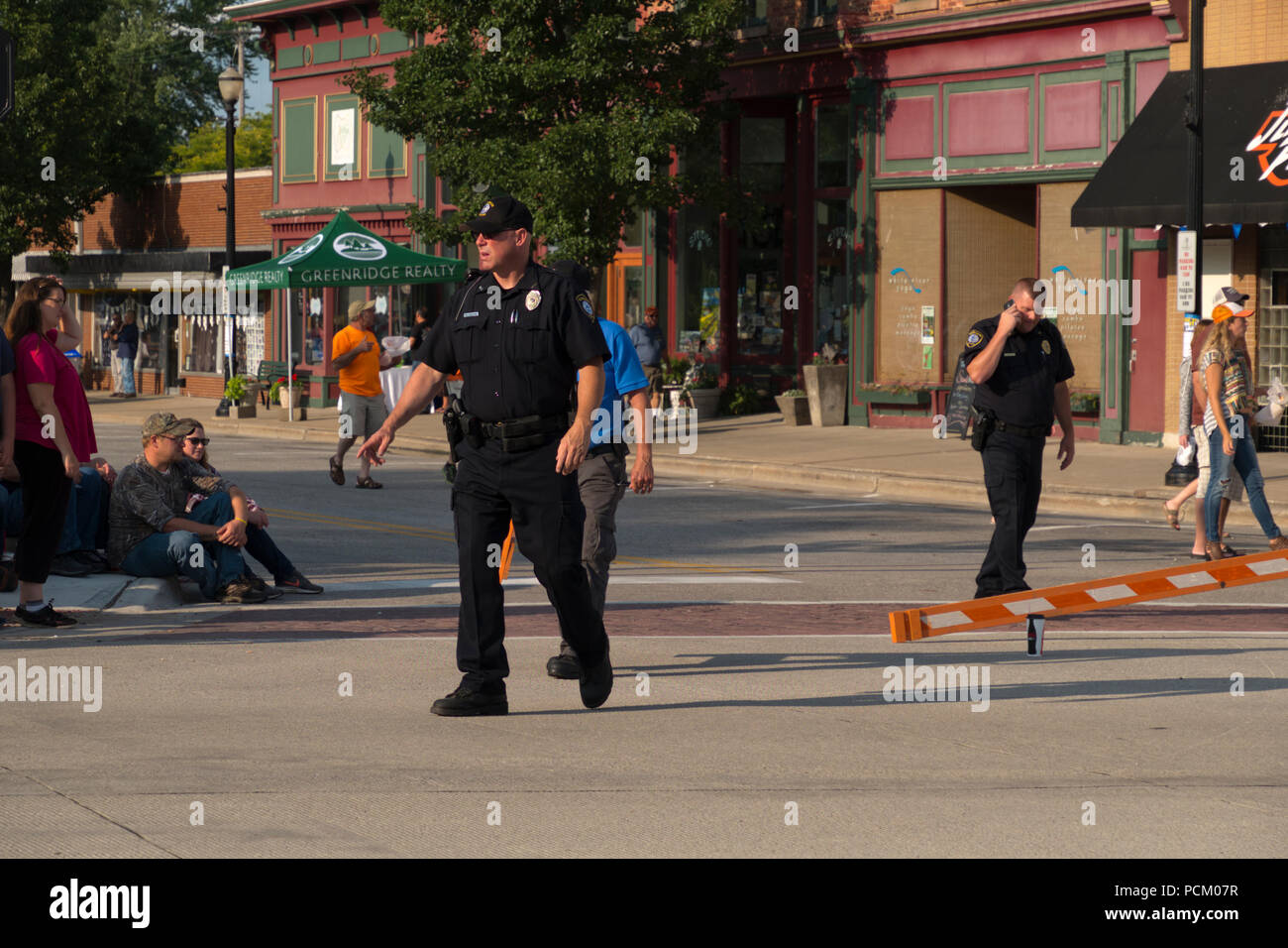 Gli ufficiali di polizia dirigere traffico in preparazione per l'annuale Cruz In antichi e vintage parata del veicolo nel centro cittadino di Montague, Michigan, Stati Uniti d'America. Foto Stock