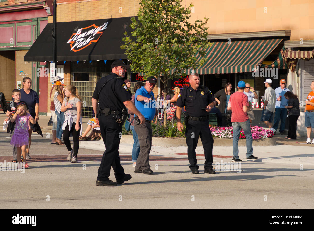 Gli ufficiali di polizia dirigere traffico in preparazione per l'annuale Cruz In antichi e vintage parata del veicolo nel centro cittadino di Montague, Michigan, Stati Uniti d'America. Foto Stock