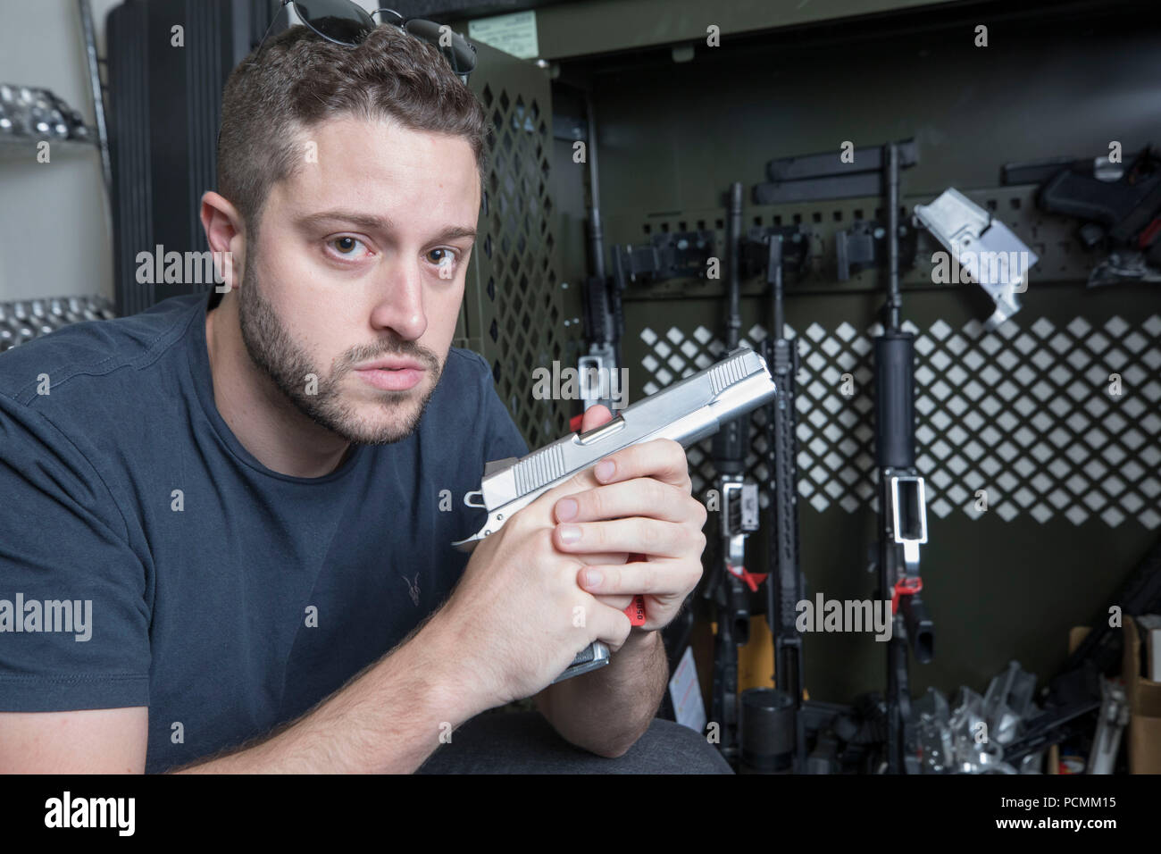 Cody Wilson, pistola attivista dei diritti e fondatore della difesa distribuita, un'azienda texana lo sviluppo e la pubblicazione di open source progettazioni di pistola per la stampa 3-D e fabbricazione. Wilson, tenendo in mano un arma di metallo, è stato citato in giudizio da numerosi avvocati generale a tenere la sua pistola di plastica piani fuori da internet. Foto Stock