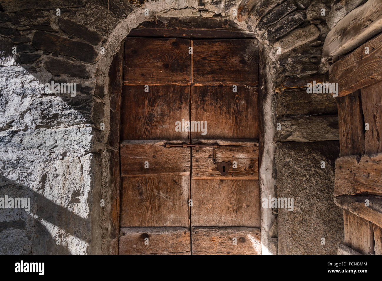 Un antico portale del medioevo una casa di pietra in abondoned villaggio montano di Savogno in Provenza di sondrio, Italia settentrionale Foto Stock