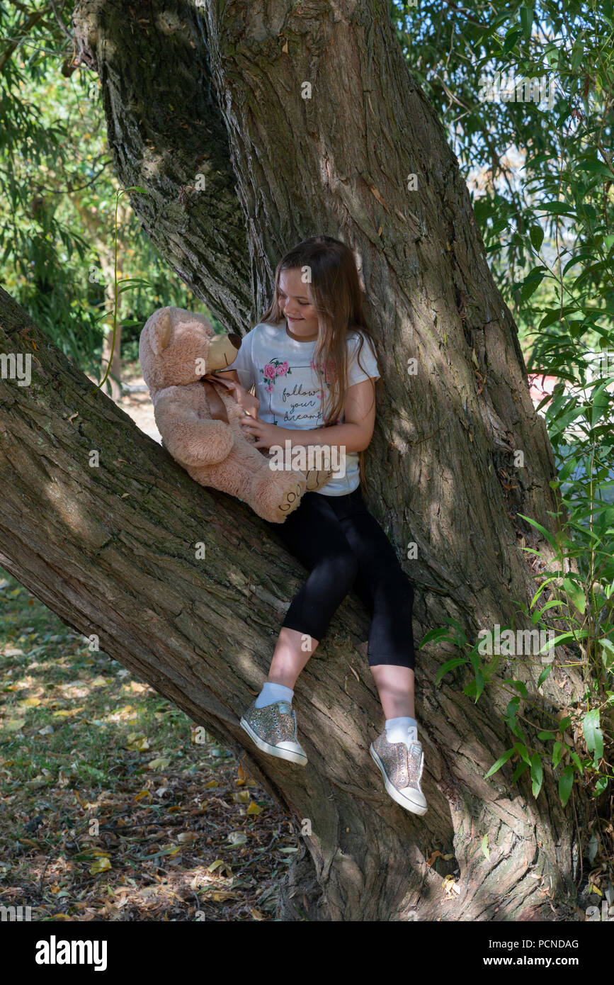 Bambina nel parco con il giocattolo di peluche Foto Stock