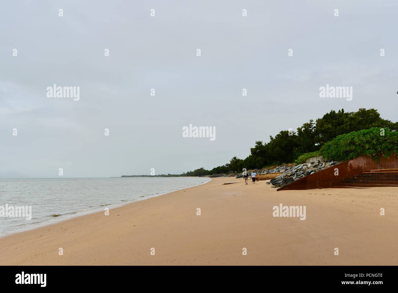 Una vecchia coppia a piedi lungo la spiaggia di Cardwell, Cardwell, Queensland, Australia Foto Stock