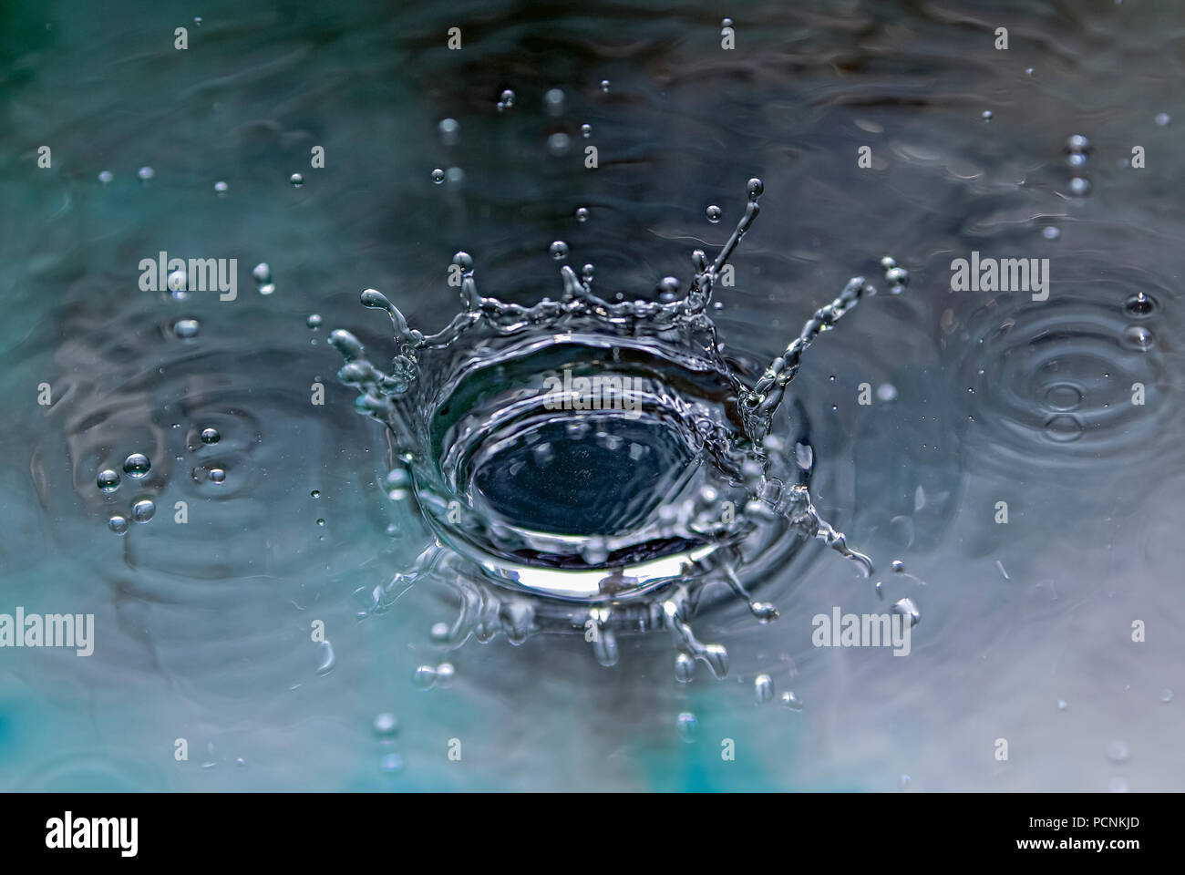 Ad alta velocità la fotografia di una gocciolina di liquido. Le terre di goccioline di liquido e produce una coronet. Foto Stock