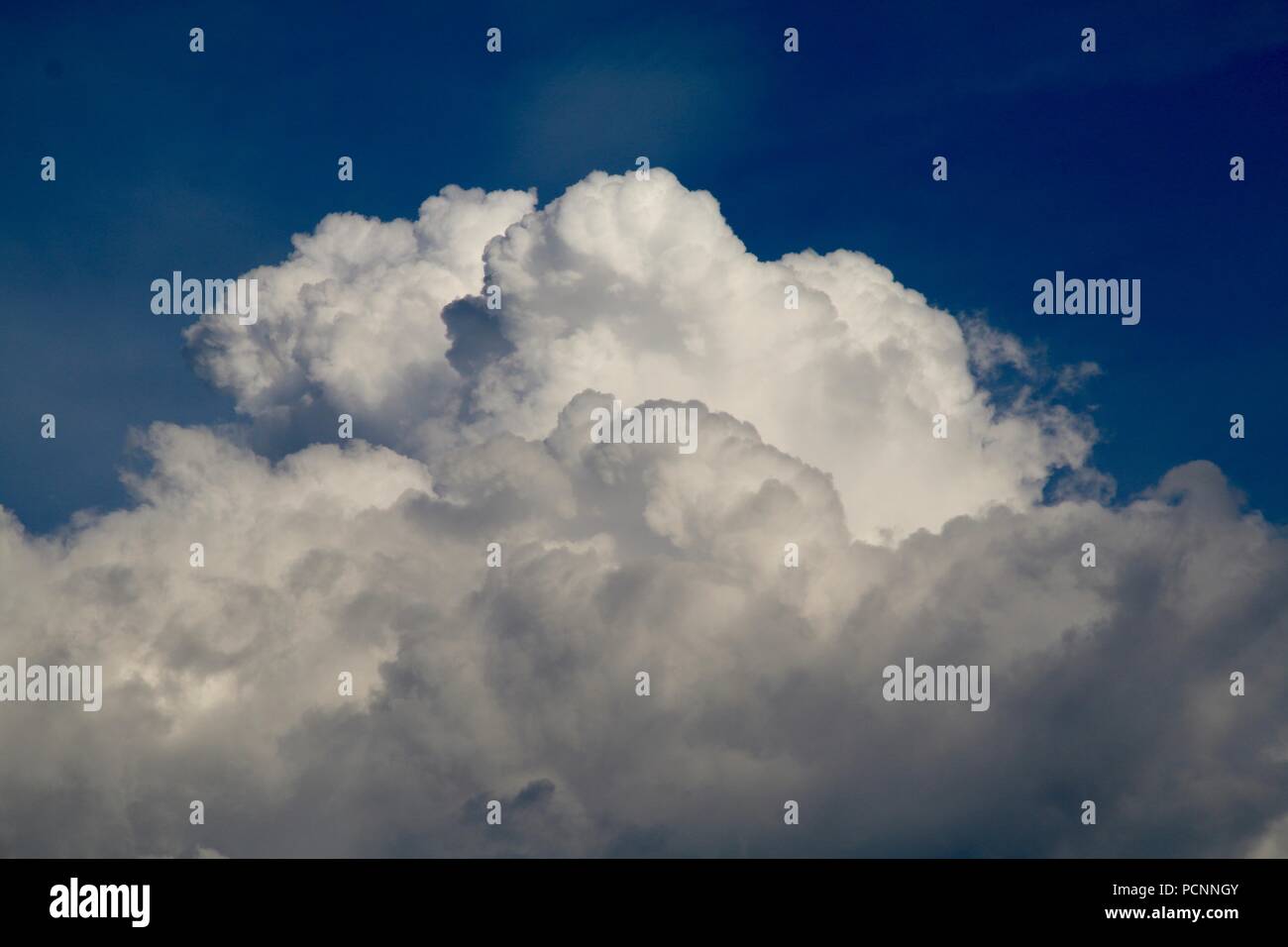 Enorme bianco soffici nuvole cumulus edificazione per una tempesta estiva Foto Stock