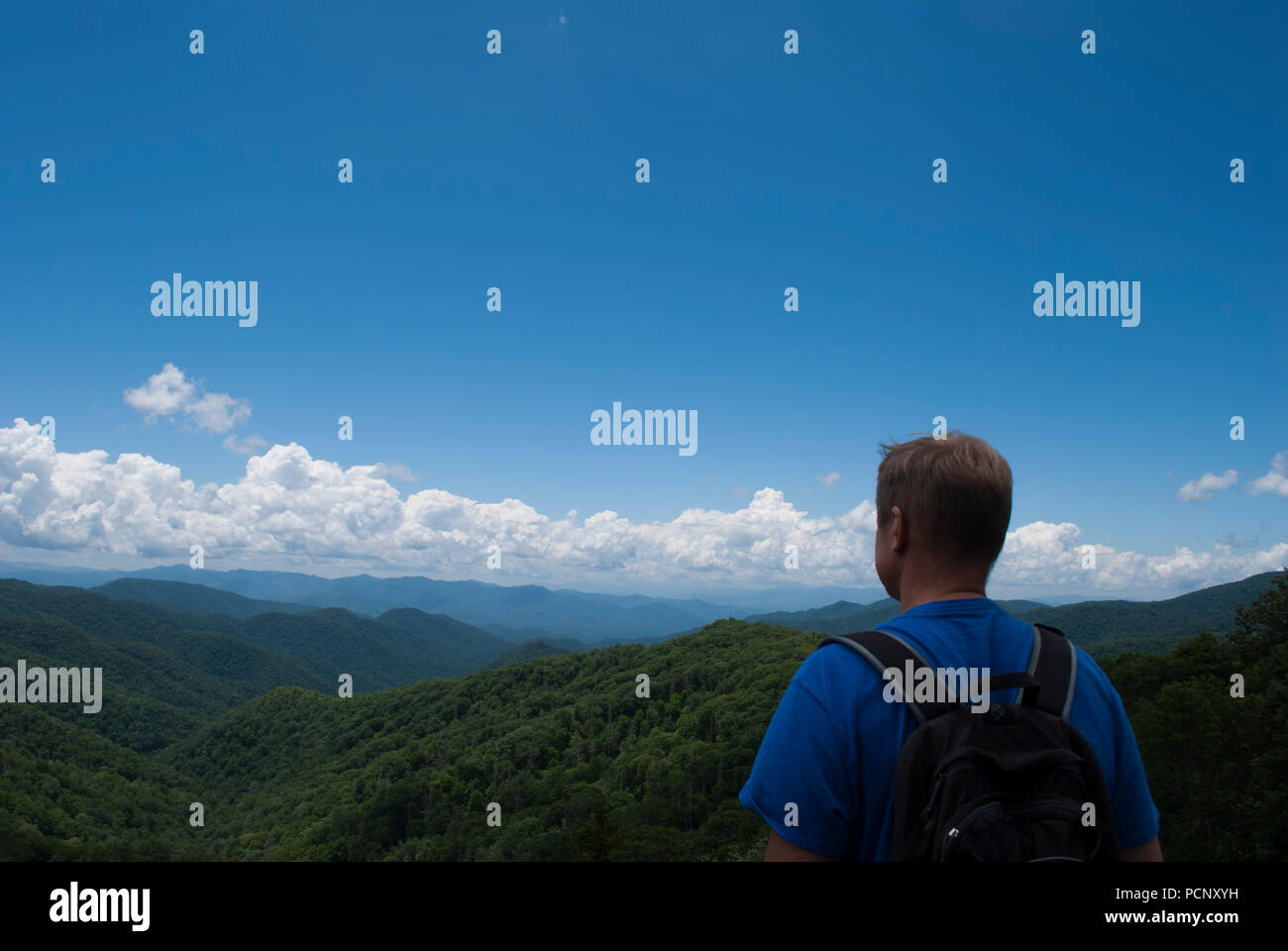 Uomo con zaino è guardando il paesaggio di montagna dalla cima della montagna Foto Stock