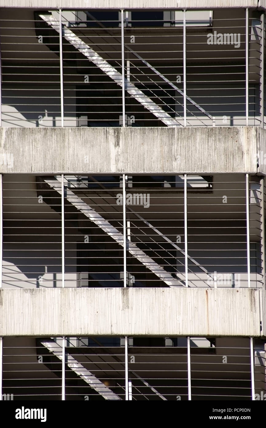 I vari piani e livelli di un garage per il parcheggio con scale dietro le sbarre e soffitti in cemento. Foto Stock