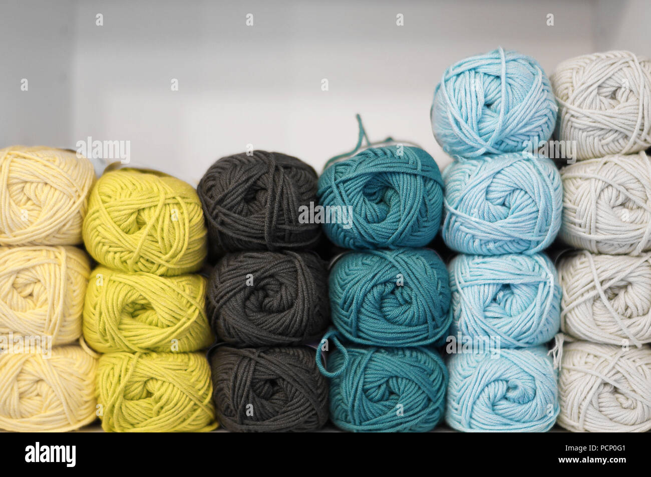 Una pila di palline di lana in colori diversi Foto Stock
