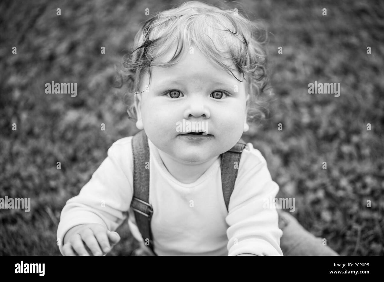 Bambino, ragazzo curioso cercando nella fotocamera, close-up, b/w Foto Stock