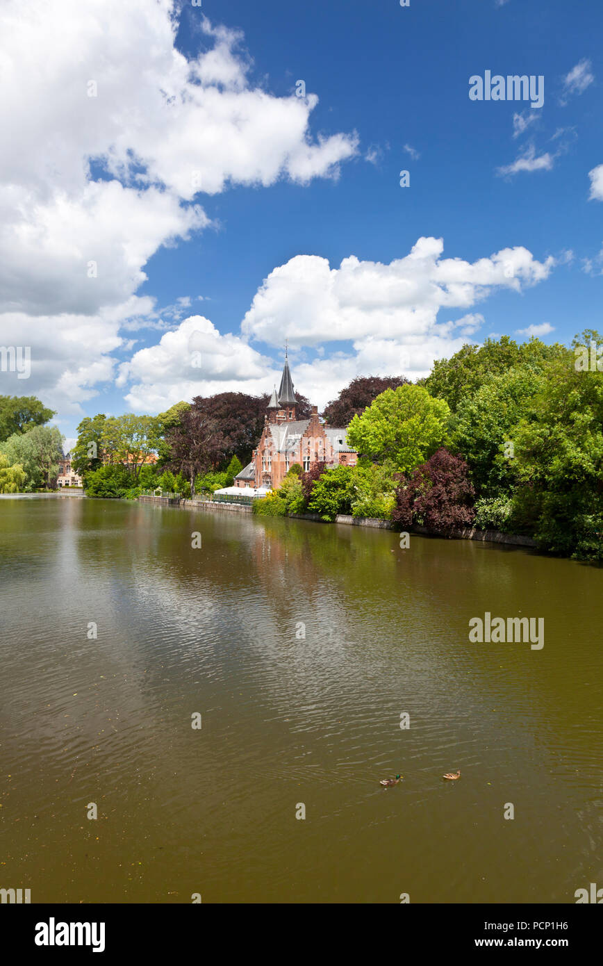 Il lago romantico Minnewater con il suo piccolo castello nel sud di Bruges, Belgio. Foto Stock