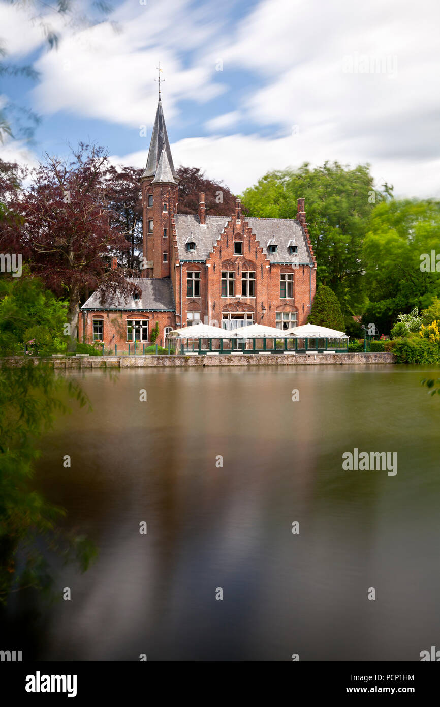 Il lago romantico Minnewater con la sua famosa casa con torri a sud di Bruges, Belgio. Una lunga esposizione shot. Foto Stock