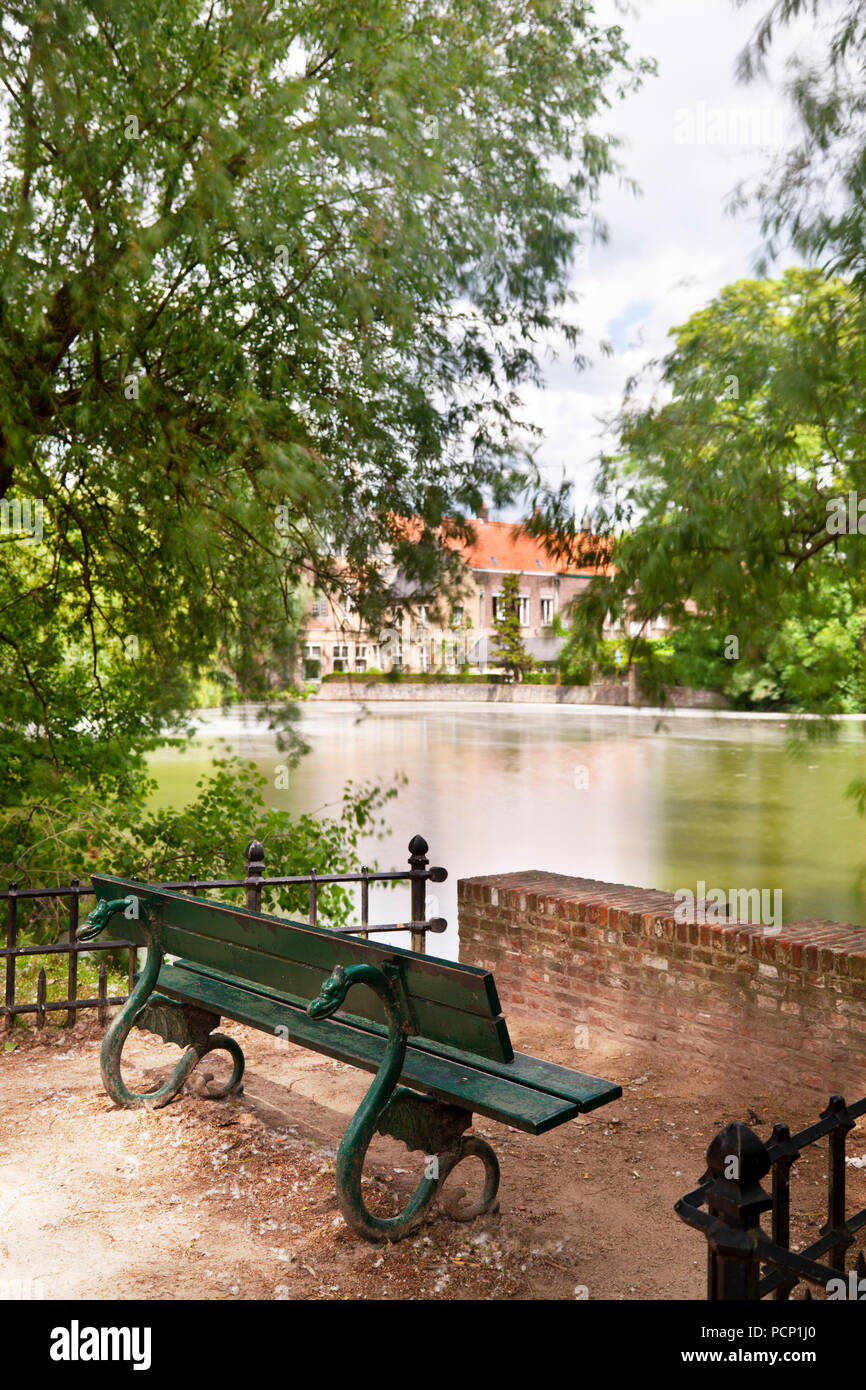Un banco di romantica sul lago Minnewater nel sud di Bruges, Belgio. Il giorno di esposizione lunga shot. Foto Stock