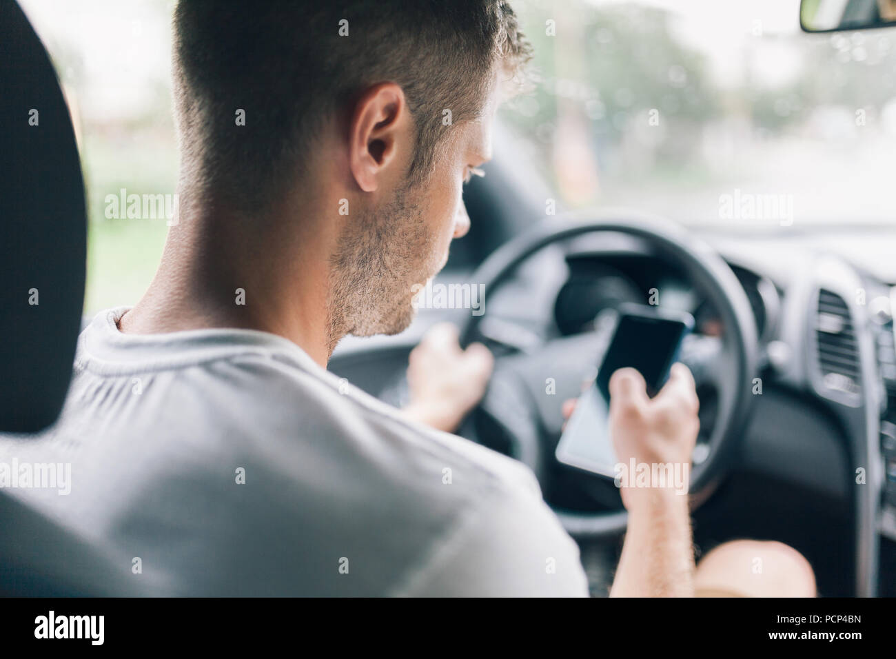 Incurante driver utilizzando il suo telefono cellulare durante la guida di una vettura Foto Stock
