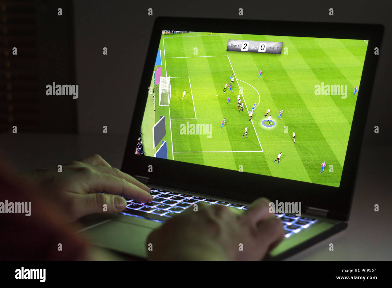 Il calcio o il calcio video gioco portatile. Giovane uomo giocando con il computer. Il gioco online e e sport concetto. Foto Stock