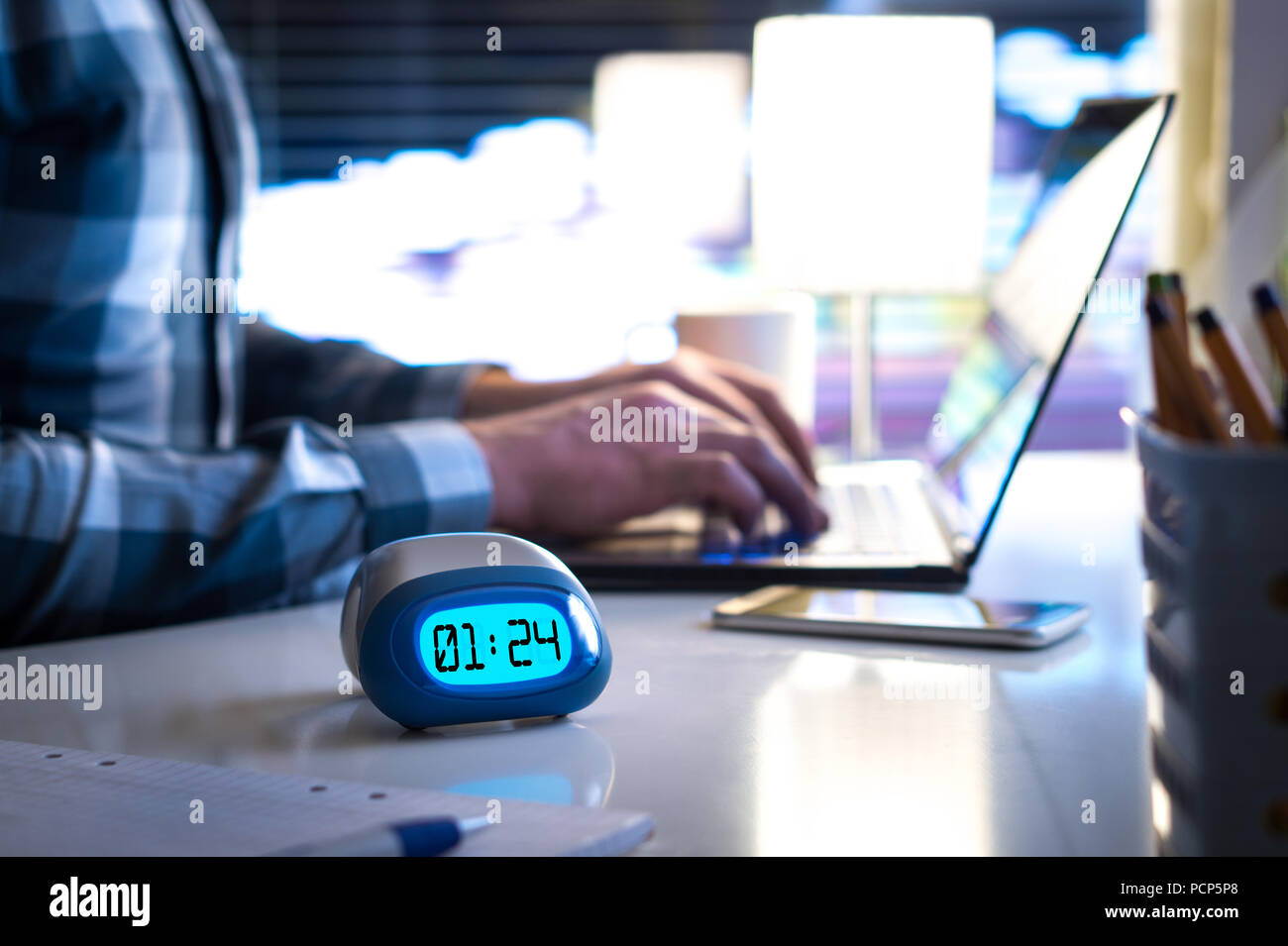 Uomo che lavora fino a tardi. Lavoro o essendo dietro il concetto di pianificazione. Persona di business in un moderno edificio di uffici o a casa durante la notte utilizzando laptop. Foto Stock