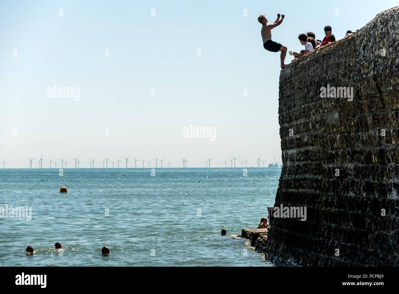 I giovani godono di raffreddamento fuori presso la spiaggia di Brighton nel tardo pomeriggio le temperature record Foto Stock
