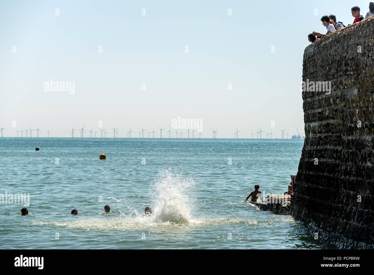 I giovani godono di raffreddamento fuori presso la spiaggia di Brighton nel tardo pomeriggio le temperature record Foto Stock