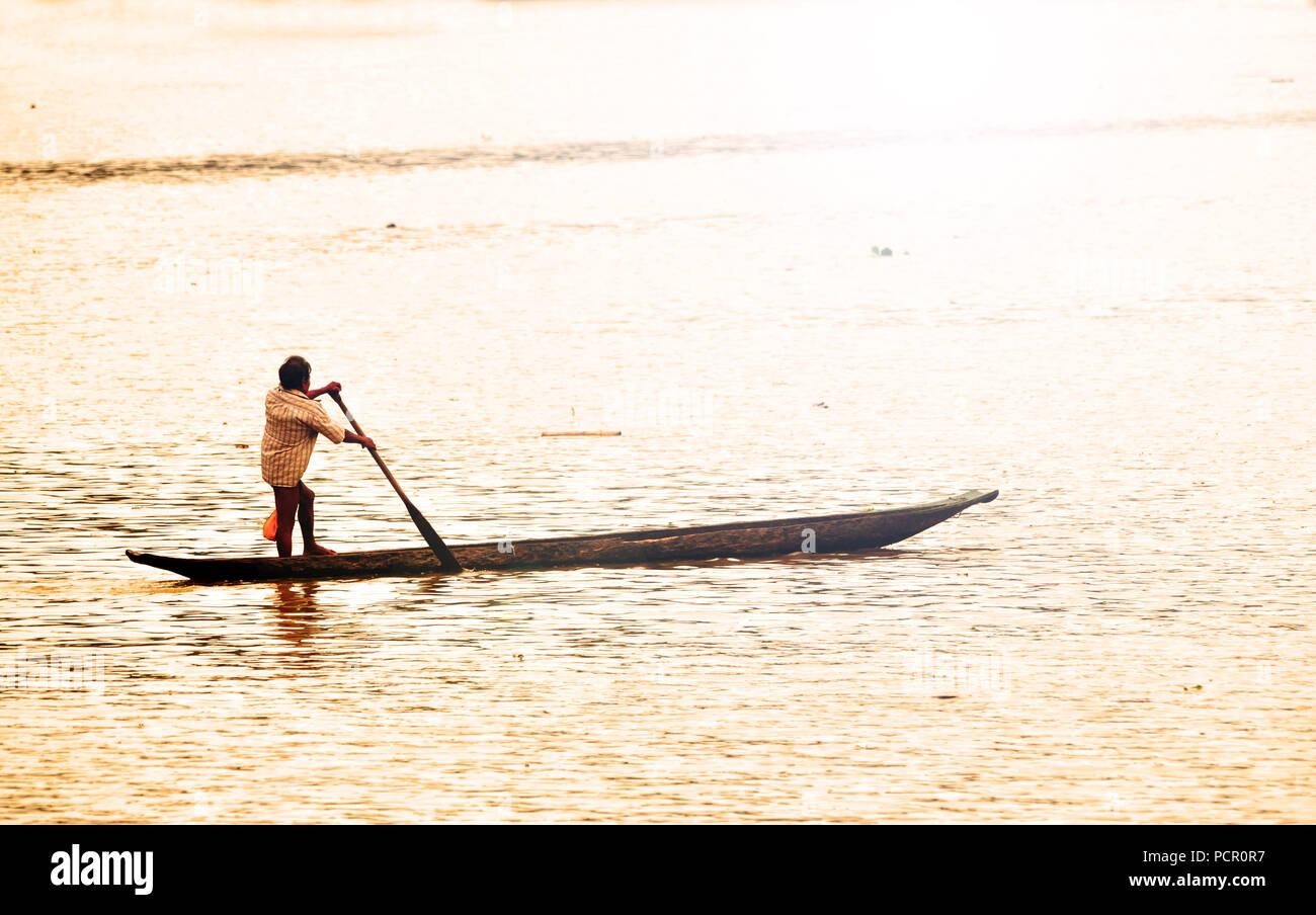 Embera Indian canottaggio la sua canoa attraverso il Fiume Chagres in Panama di sunrise Foto Stock