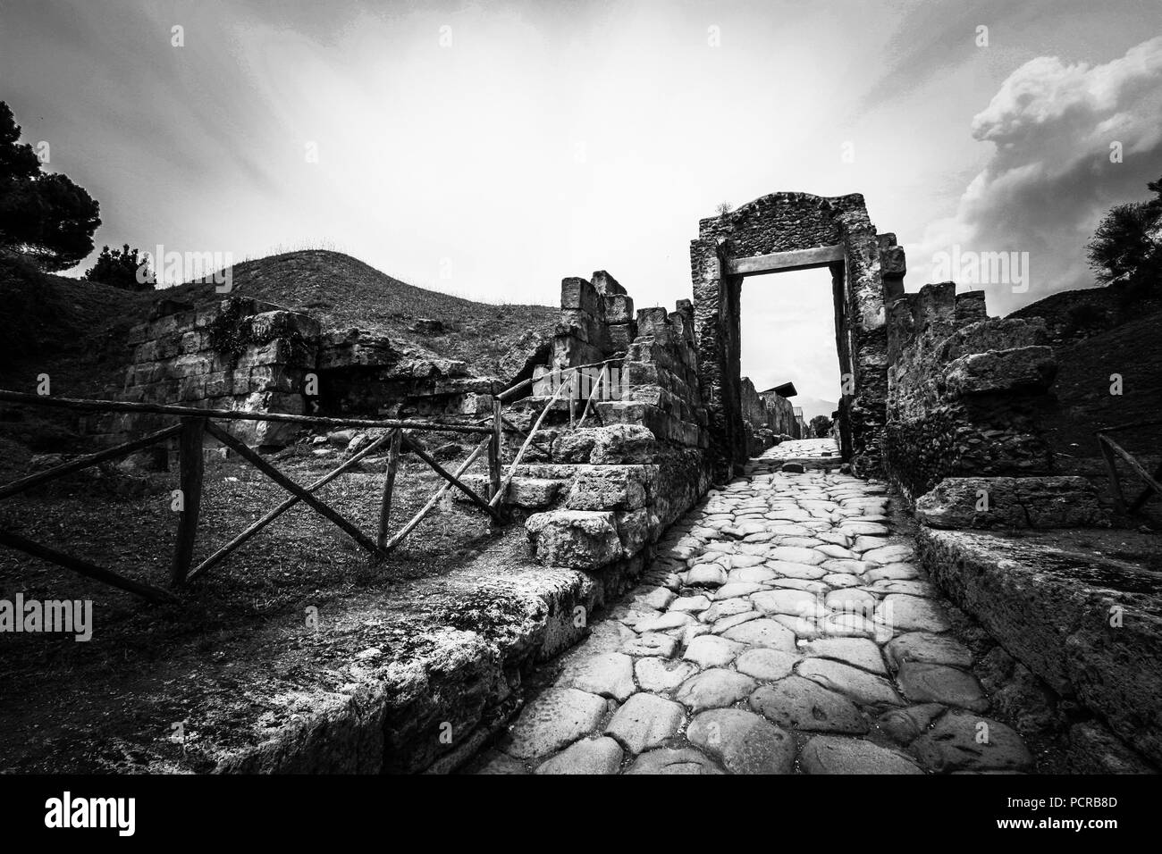 Strada di ciottoli che conduce attraverso una sorta di porta verso il centro della città di antiche città di Pompei e vicino a Napoli, Italia Foto Stock